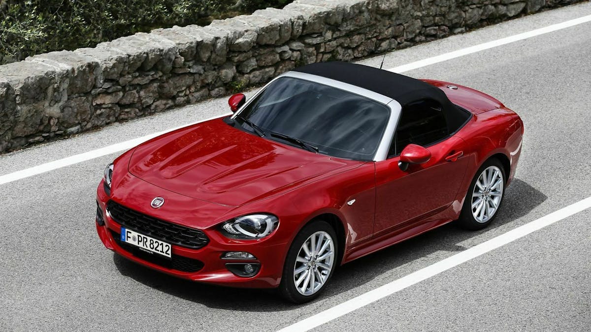Roter Fiat 124 Spider Auslaufmodell mit geschlossenem Verdeck, stehend auf einer Straße