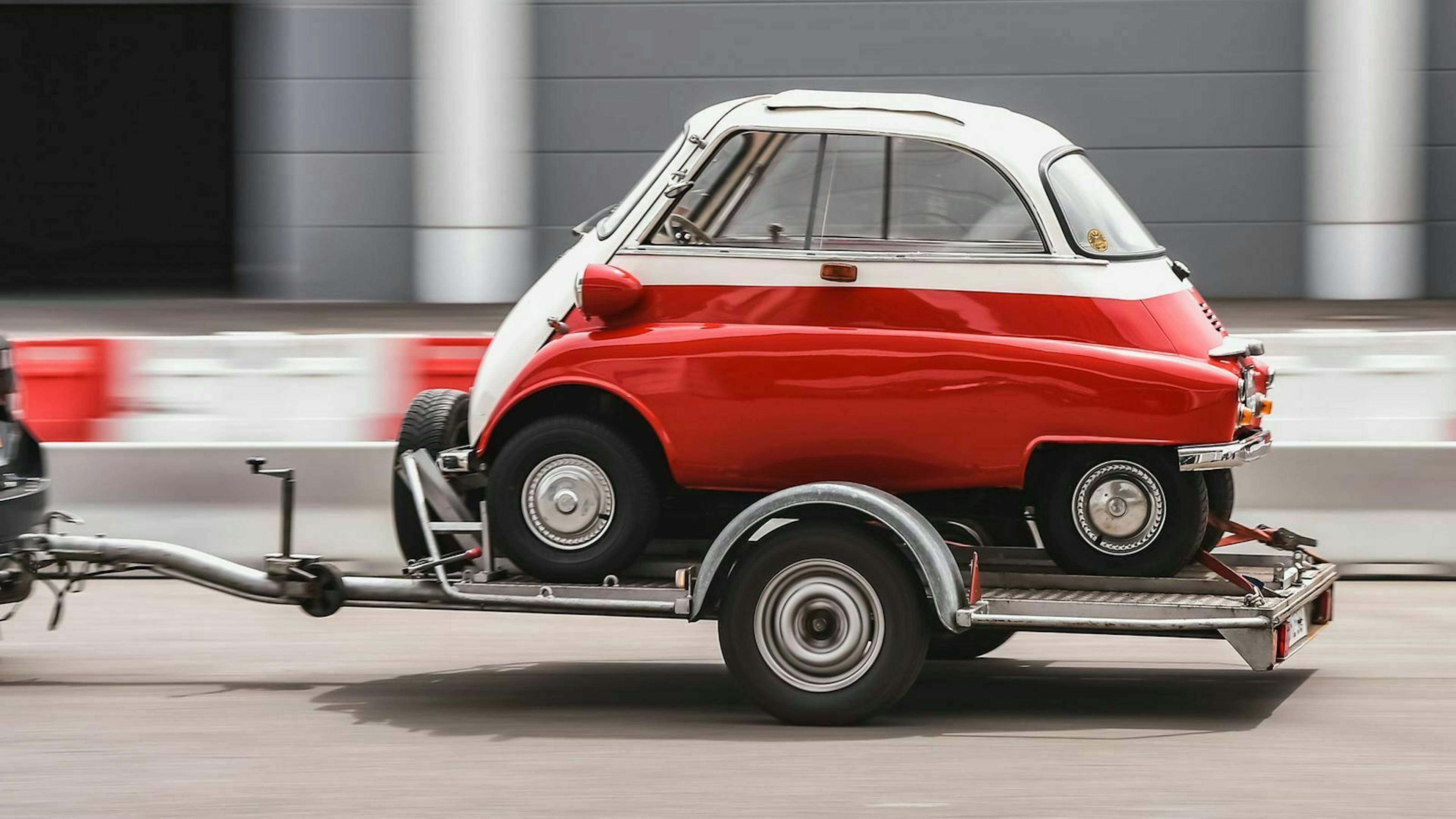 Eine rote BMW Isetta wird auf einem Anhänger transportiert.