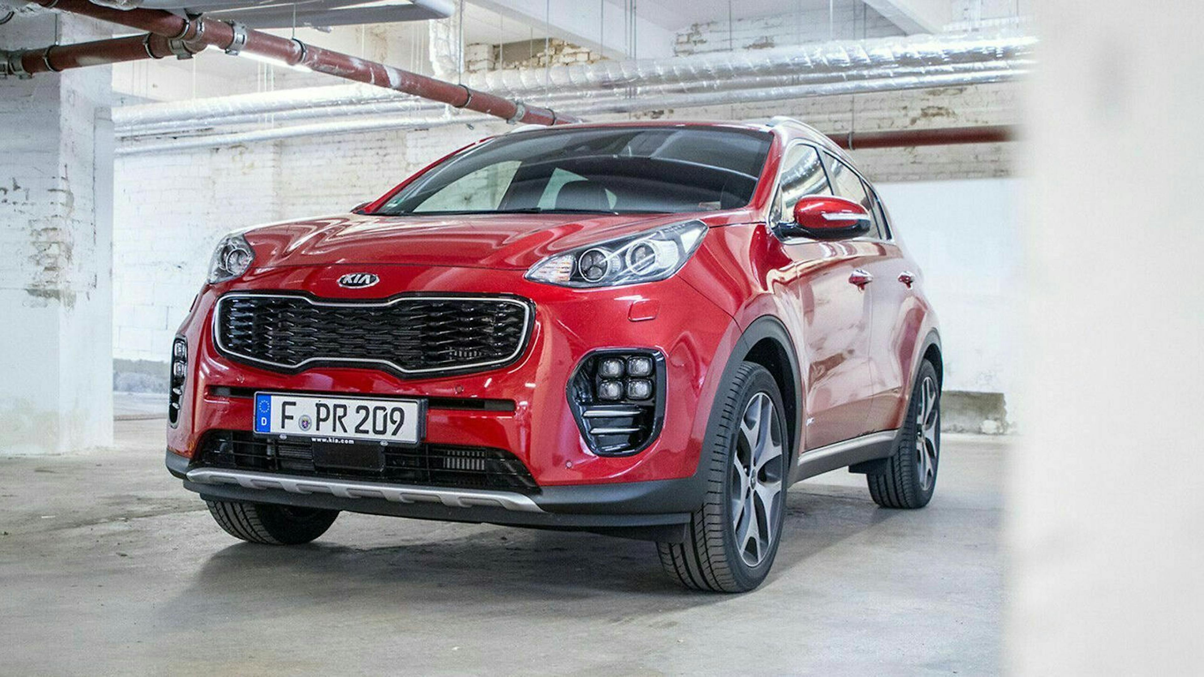 Ein roter Kia Sportage steht in einer Tiefgarage.