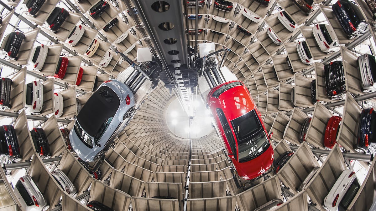 Zwei Autos werden in einem Lager von einer automatischen Hebevorrichtung einsortiert
