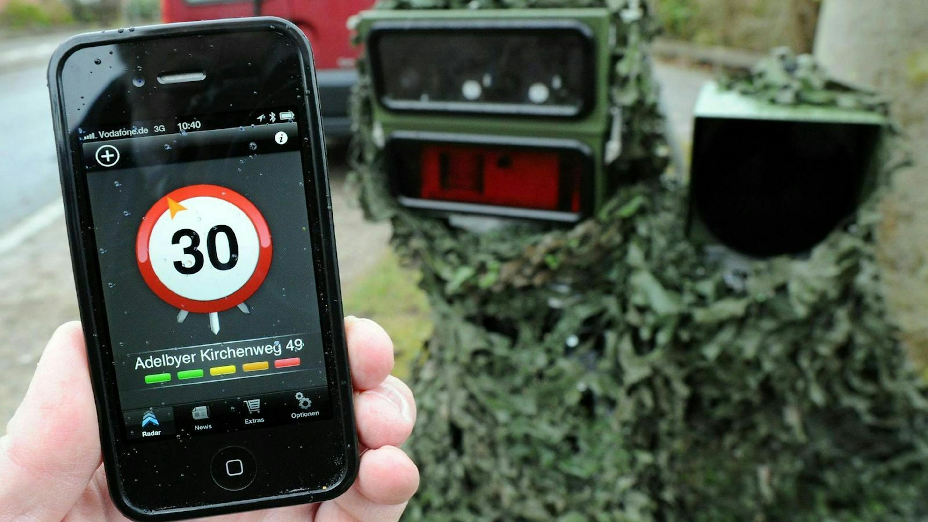 Handy mit Radar-App vor Blitzerfalle