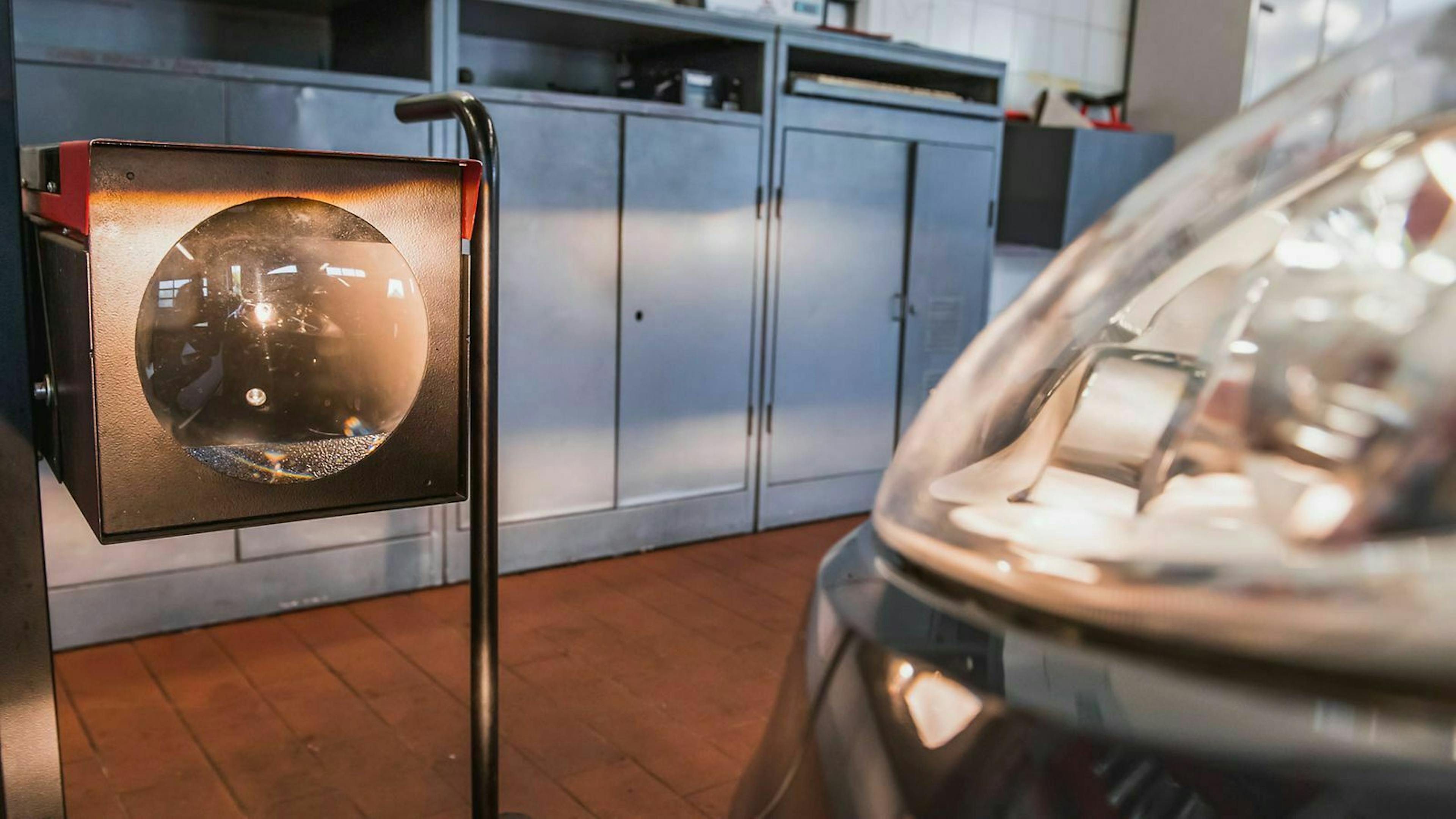 In Nahaufnahme ist ein Messgerät zur Justierung von scheinwerfern zu sehen, das in einer Werkstatt steht.