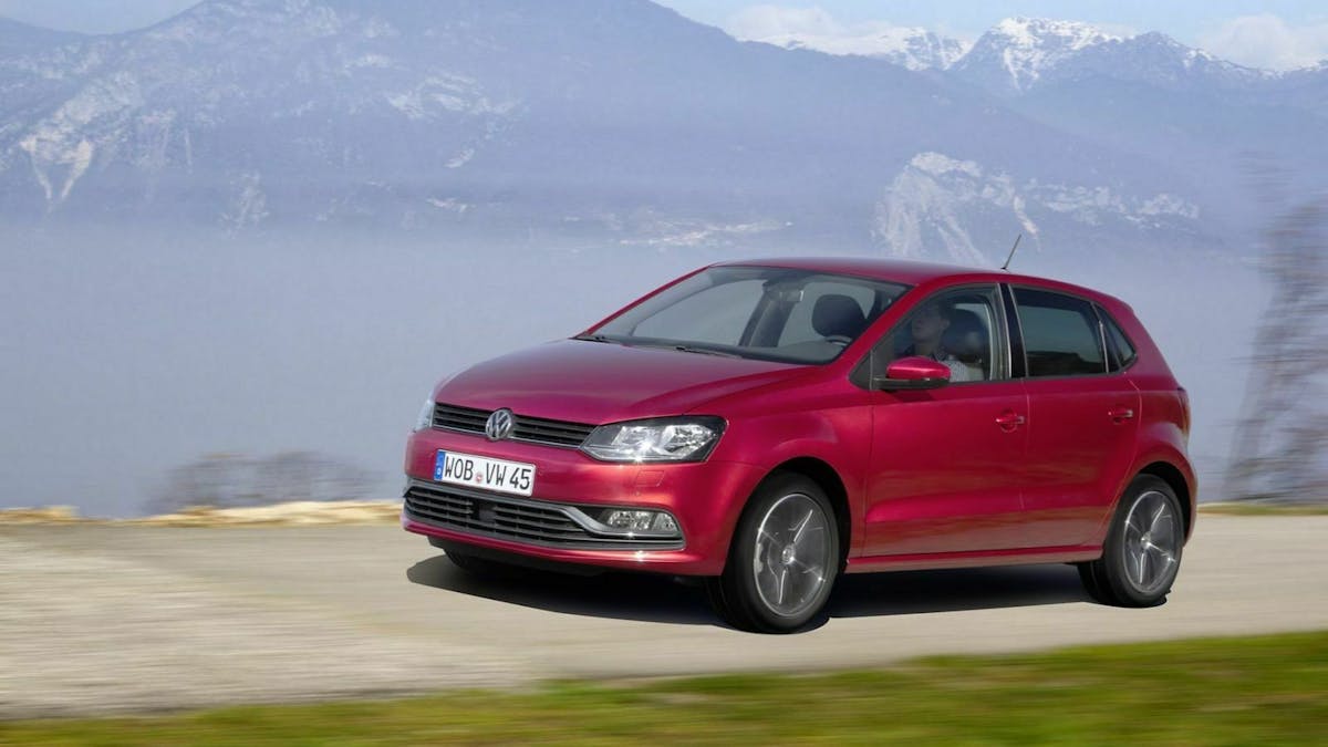 VW Polo fahrend in der Ansicht von vorne-links. Im Hintergrund ein Bergpanorama