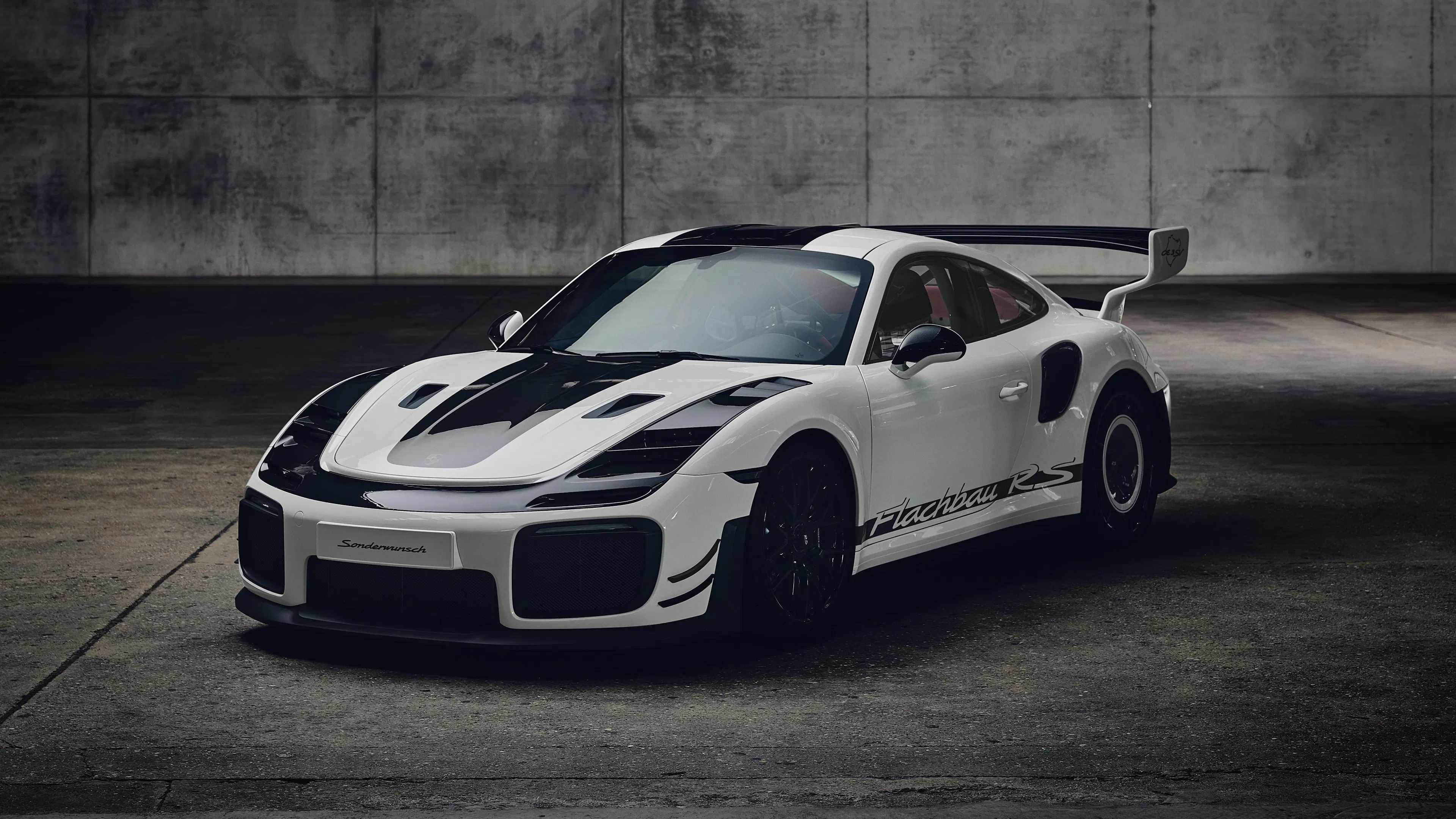 Porsche Sonderwunsch Flachbau RS in Grandprixweiß, Seitenansicht mit charakteristischem Flachbau-Profil und großem Heckflügel.