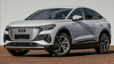 Ein silberner Audi Q4 e-Tron steht vor einer weißen Wand