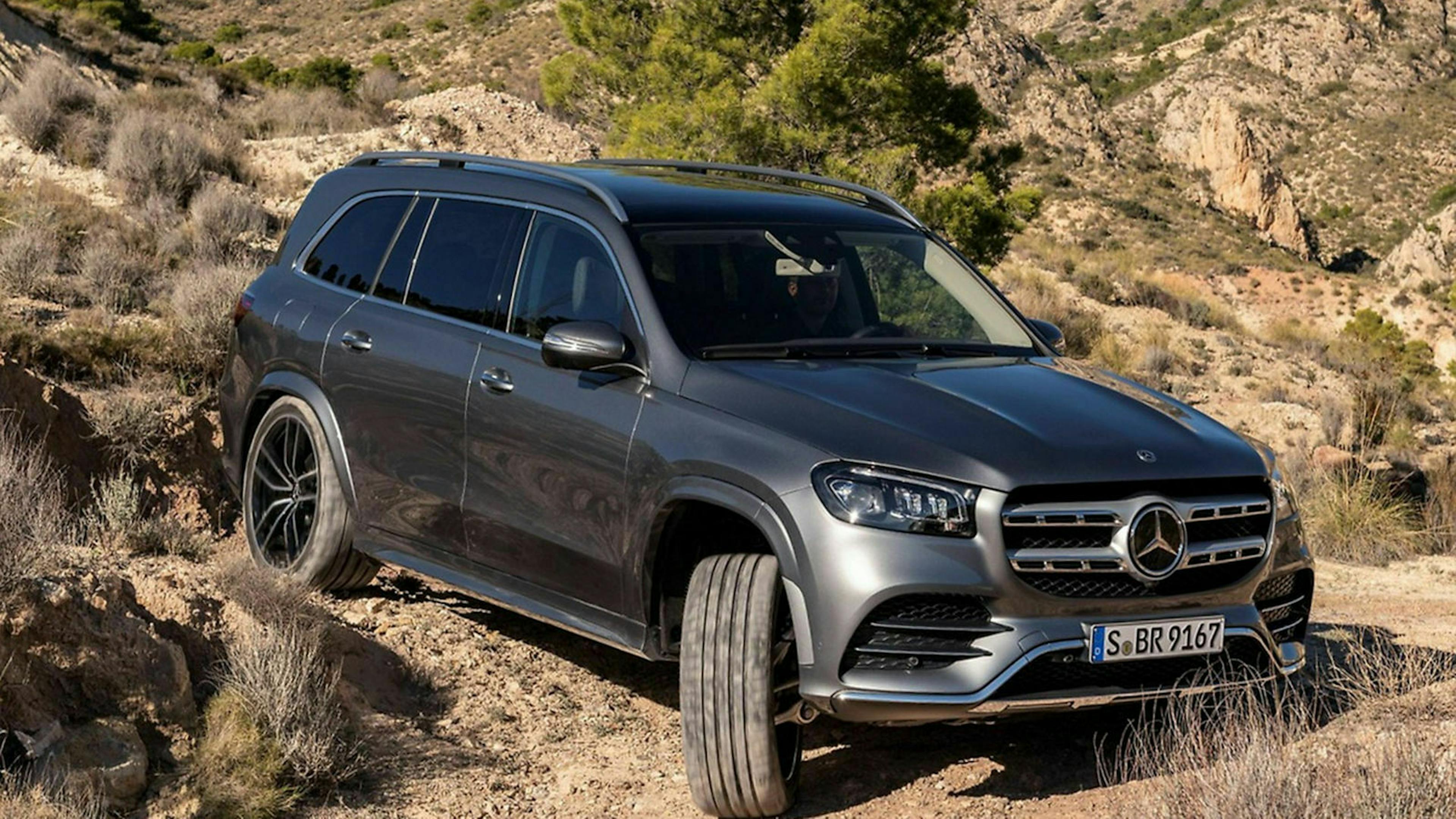 Ein brauner Mercedes-Benz GLS fährt offroad durch ein Wüstengelände