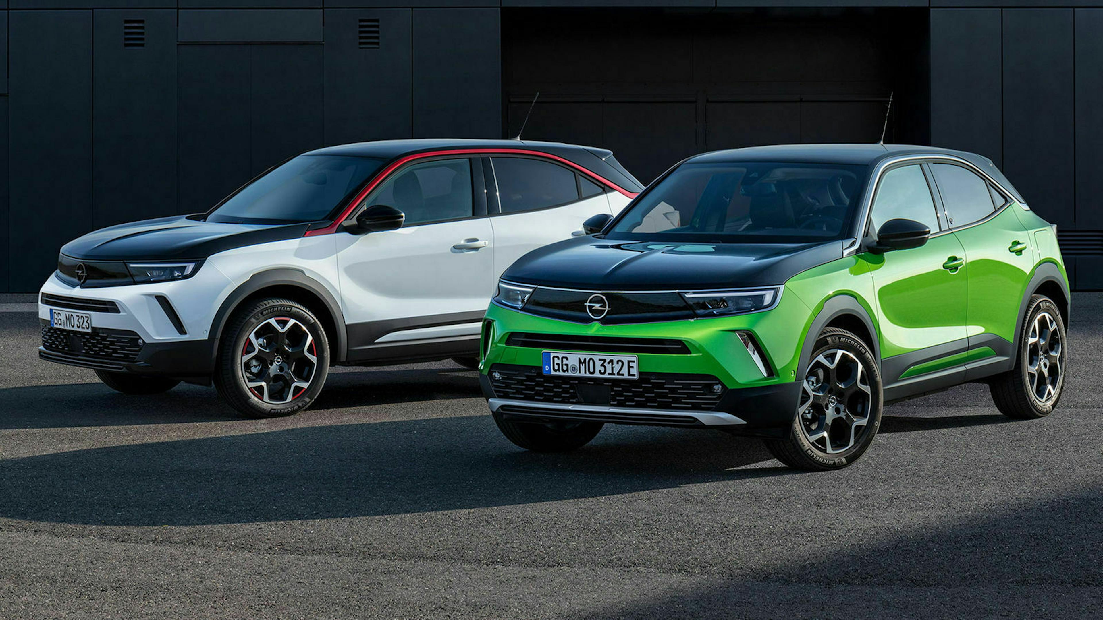 Zwei Opel Mokka, davon ein Mokka E, stehen auf einem Parkplatz