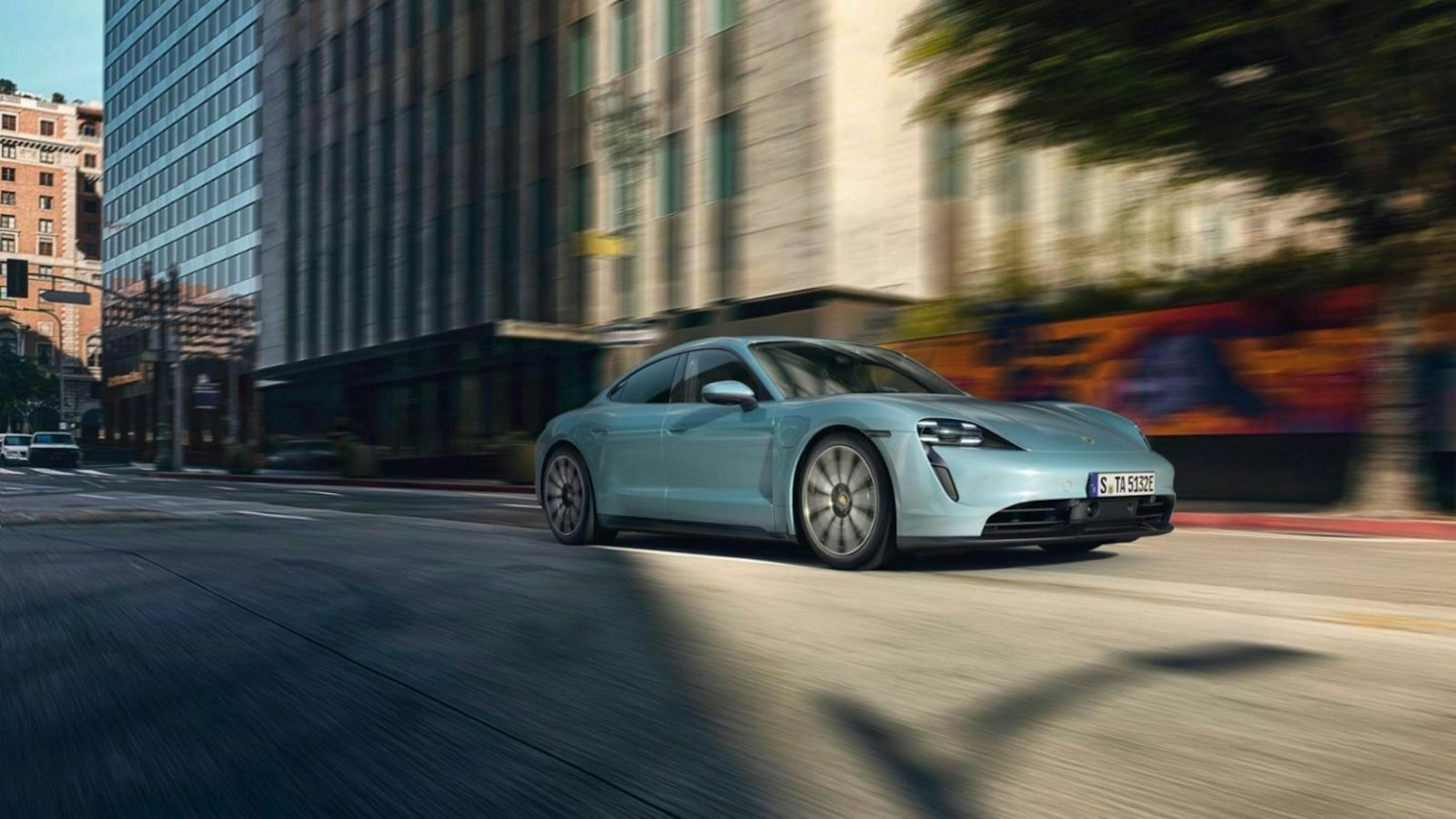 Ein blauer Porsche Taycan 4S fährt durch eine Stadt