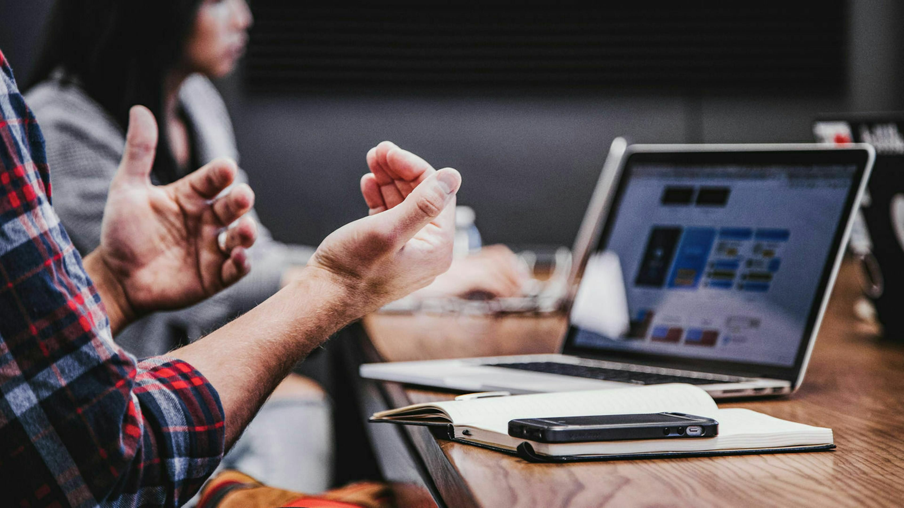 Jemand sitzt an einem Laptop auf dem unscharf ein KFZ-Versicherungsvergleich zu sehen ist.