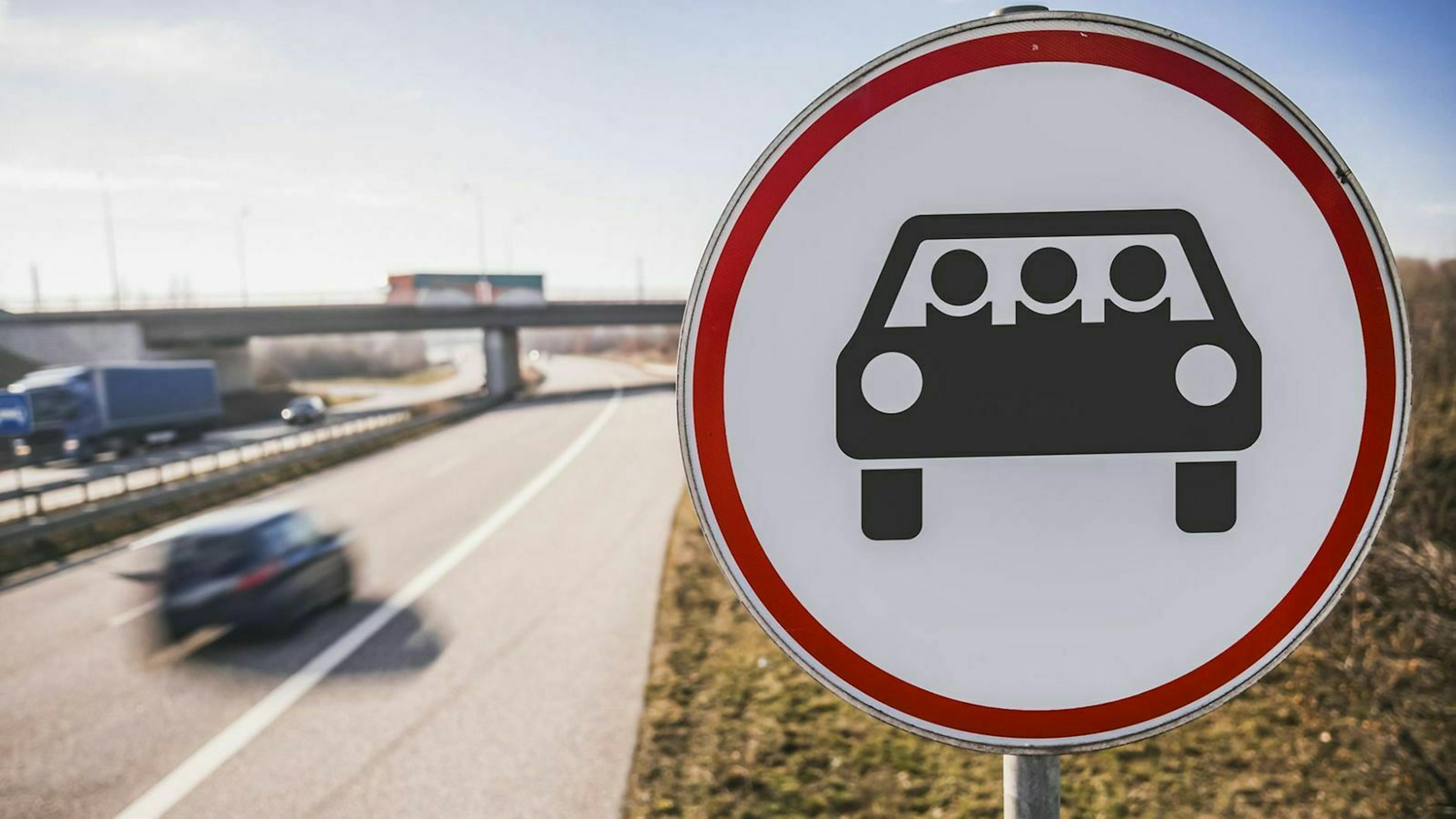 Ein Verkehrsschild, auf dem ein Pkw mit drei Personen abgebildet ist