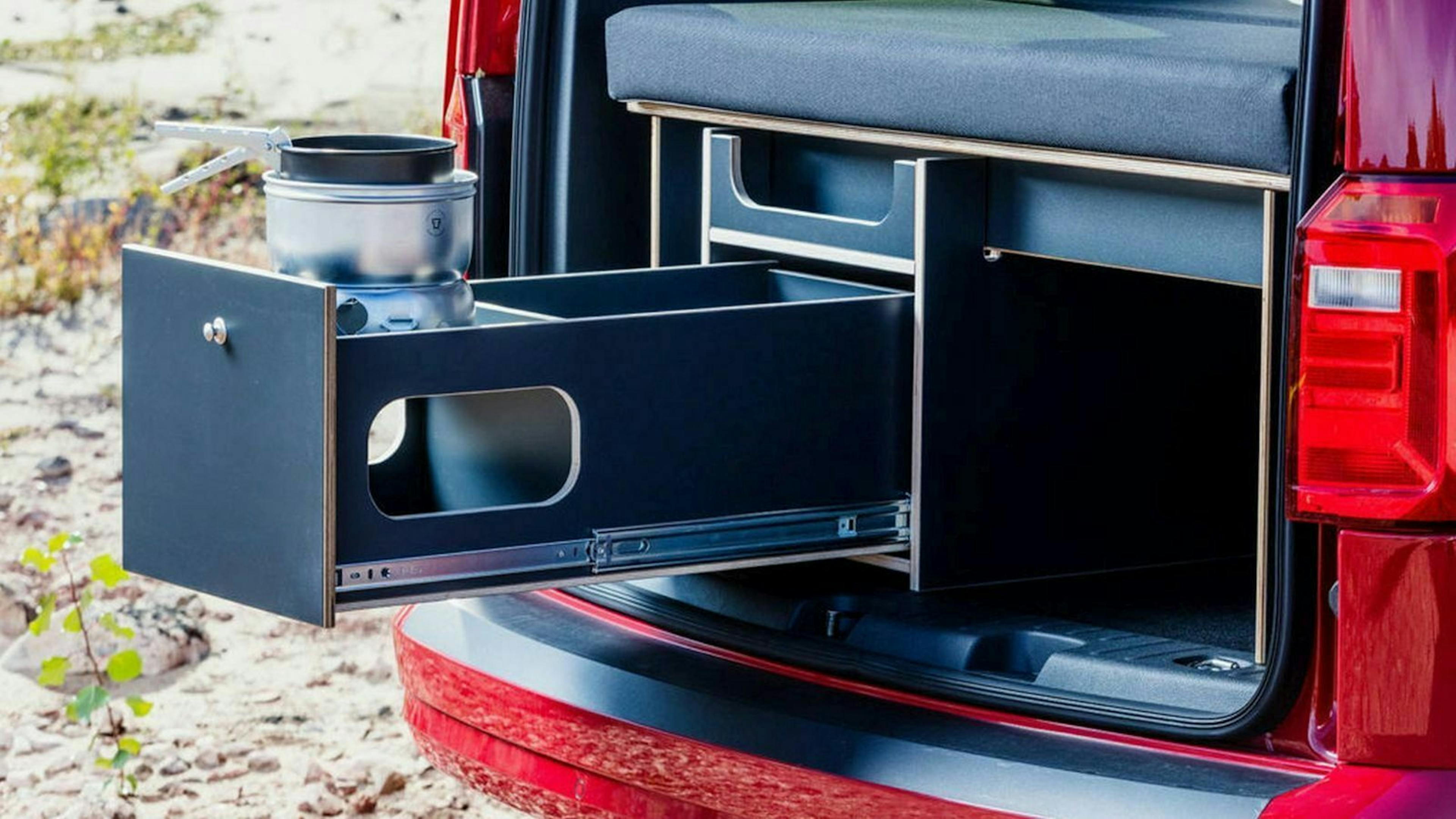 Zu sehen ist eine Schublade inklusive Gaskocher im Kofferraum des Kauai Camper Vans