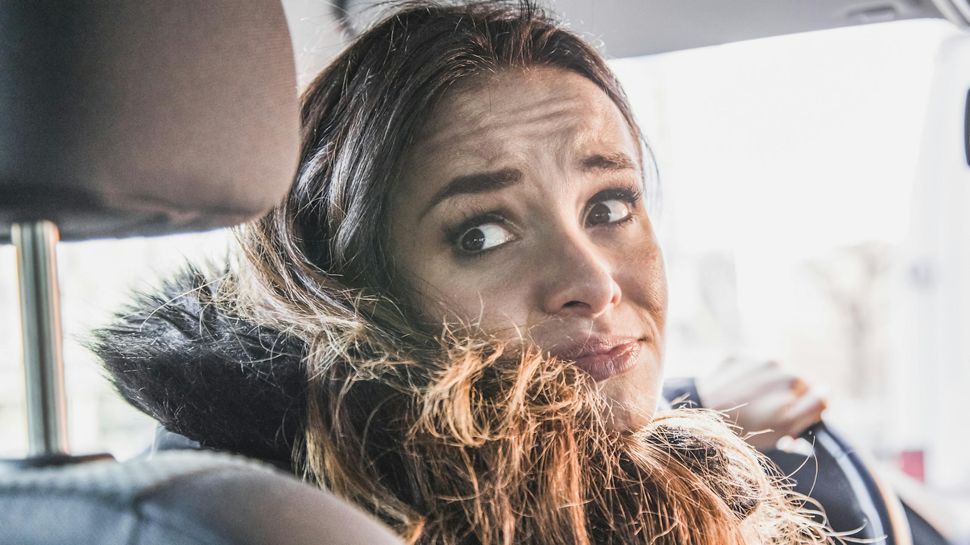 Jemand wirft beim Rückwärtsfahren einen ängstlichen Blick über die Schulter 