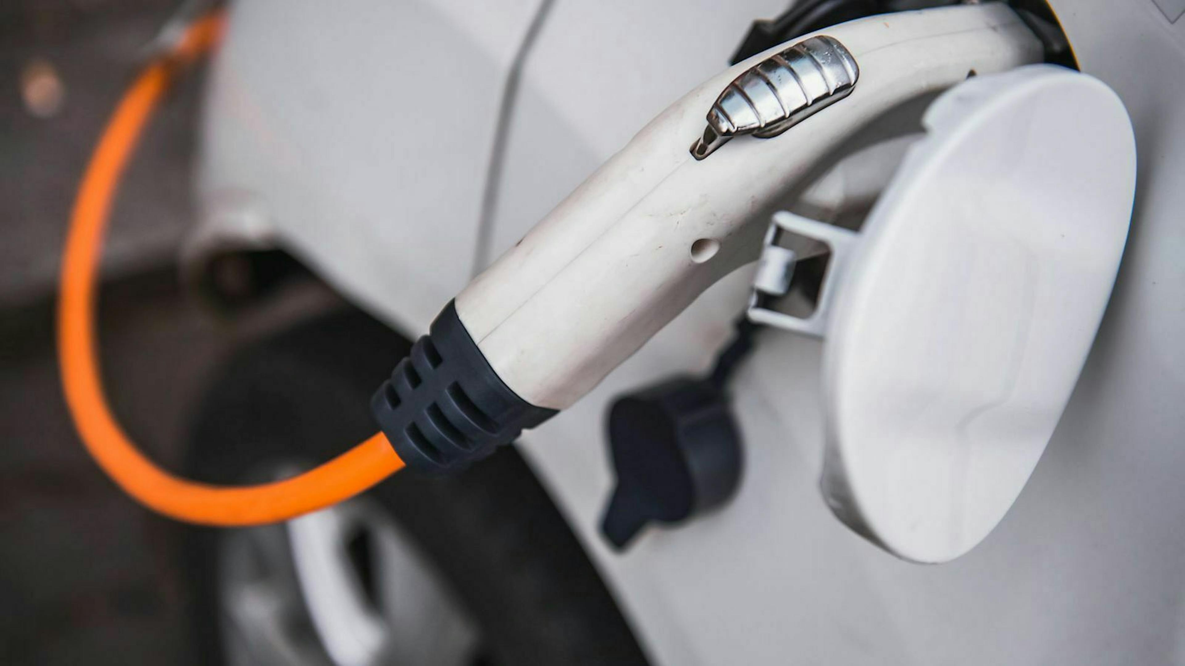 Der Stecker einer Ladesäule steckt in einem Elektroauto.