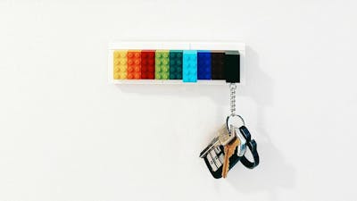 Ein Schlüsselbund mit einem Autoschlüssel hängt an einem bunten Schlüsselbrett