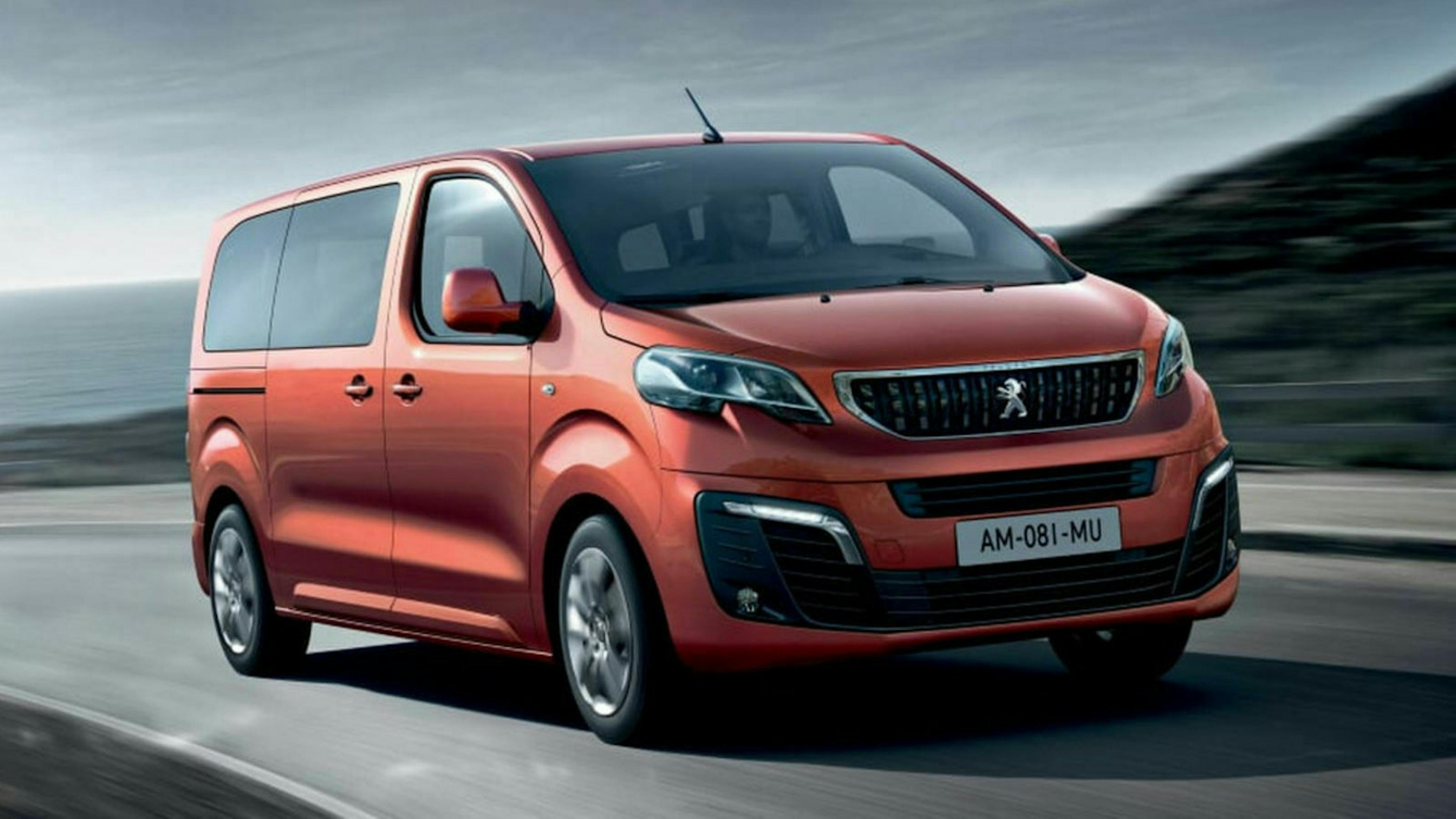 Ein roter Peugeot Traveller fährt eine Landstraße entlang