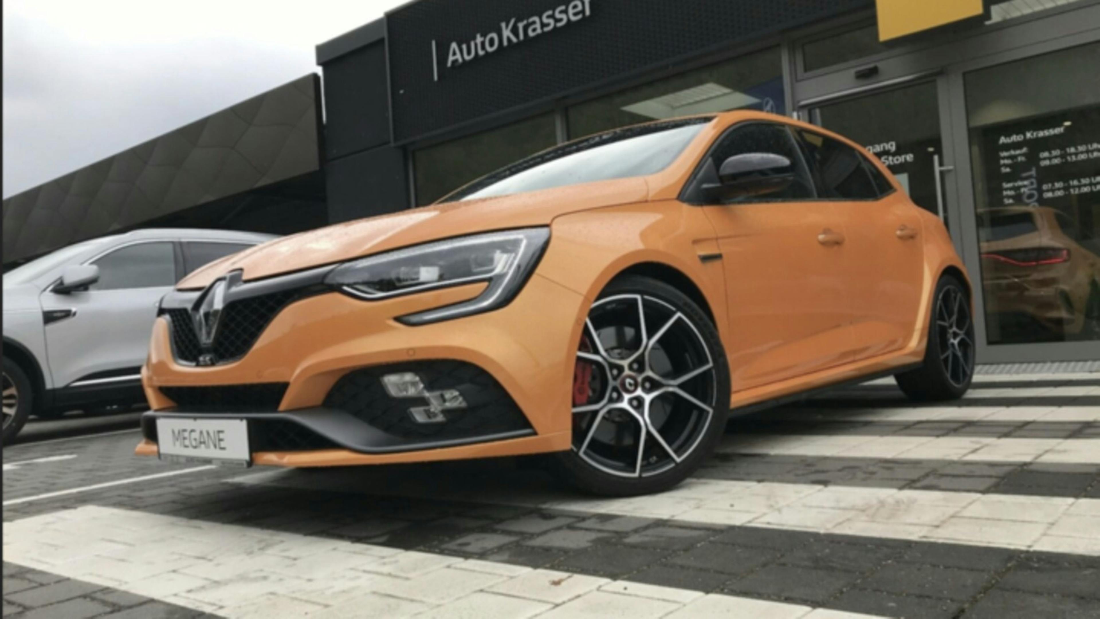 Ein orangener Renault Megane R.S. steht auf dem Parkplatz eines Autohauses