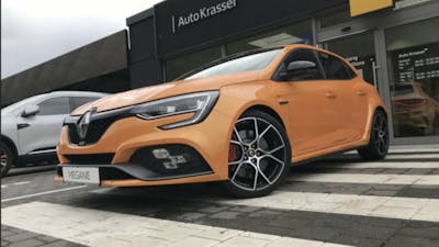 Ein orangener Renault Megane R.S. steht auf dem Parkplatz eines Autohauses