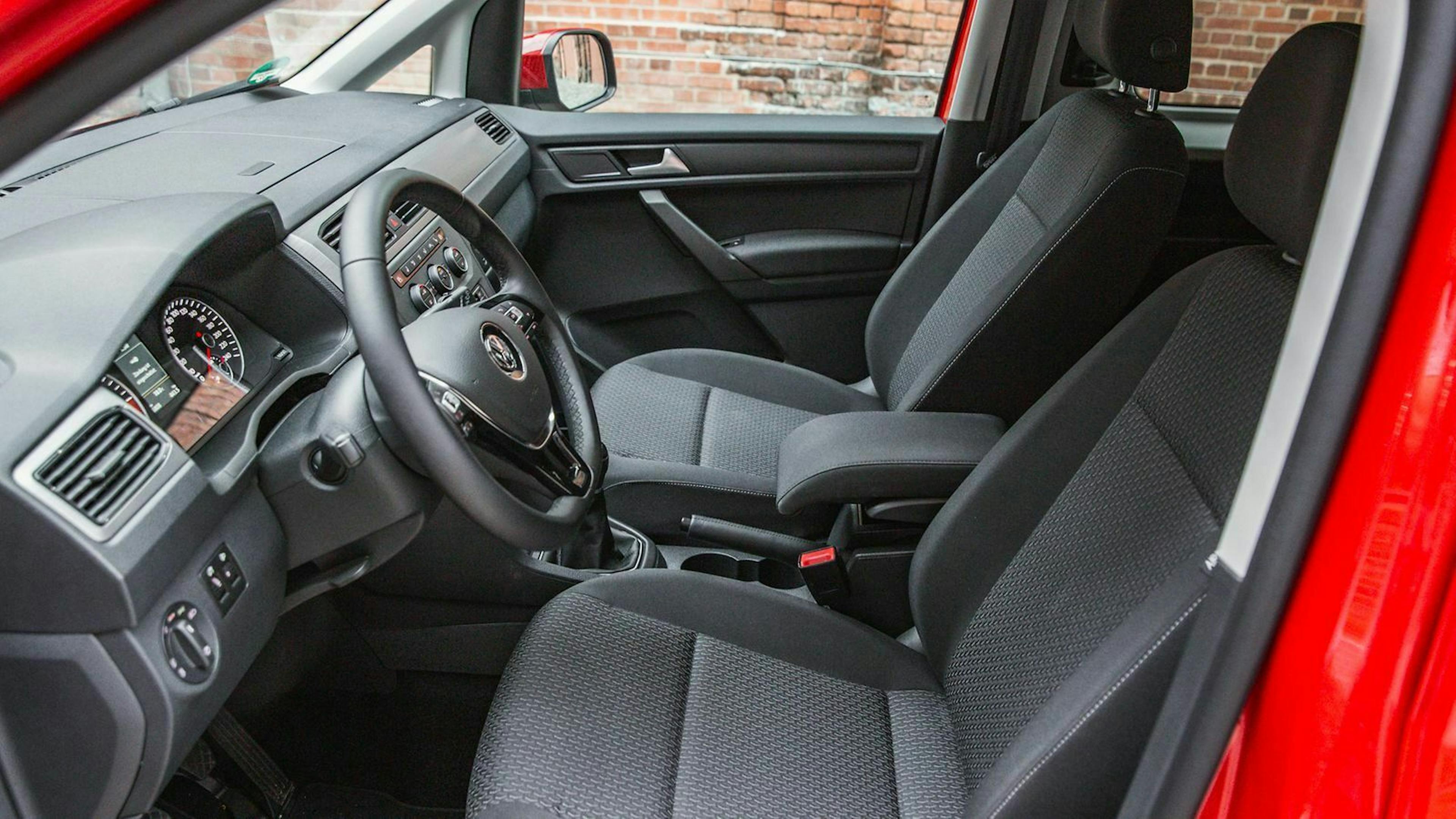 Blick durch die Seitentür auf die Vordersitze des VW Caddy