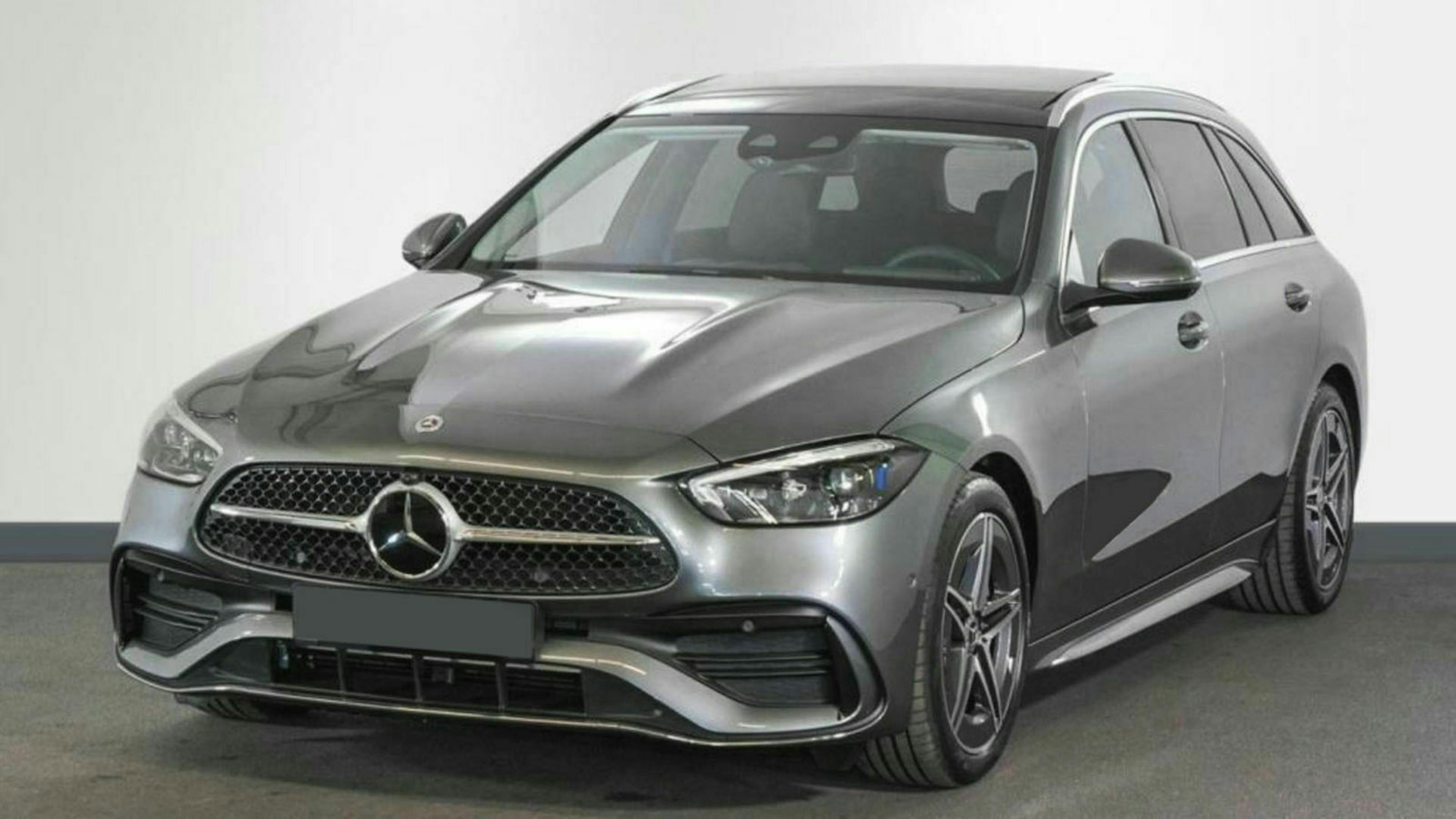 Eine dunkelgraue Mercedes-Benz C-Klasse steht vor einem weißen Hintergrund