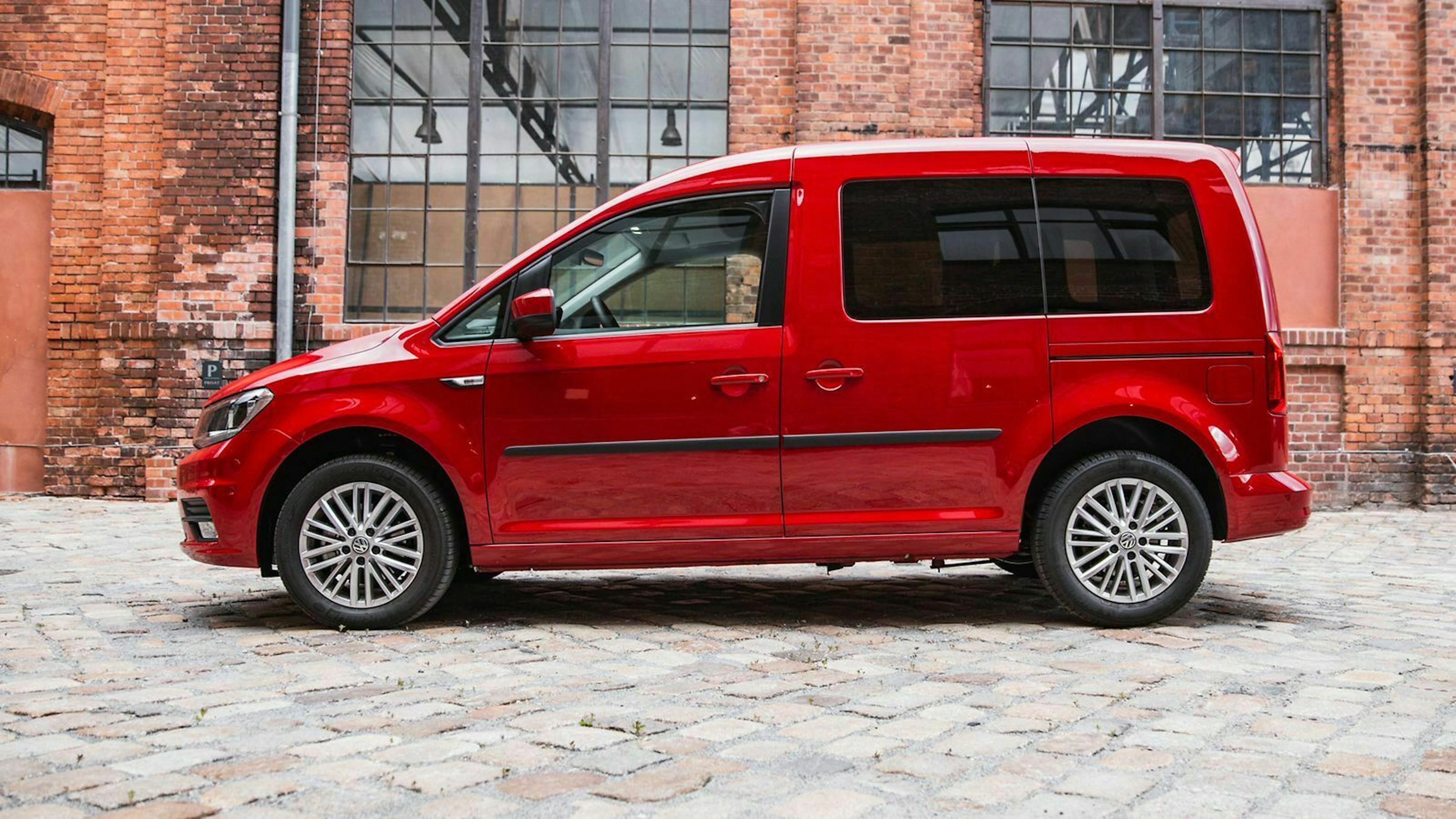 Ein roter VW Caddy mit Alufelgen in der Seitenansicht