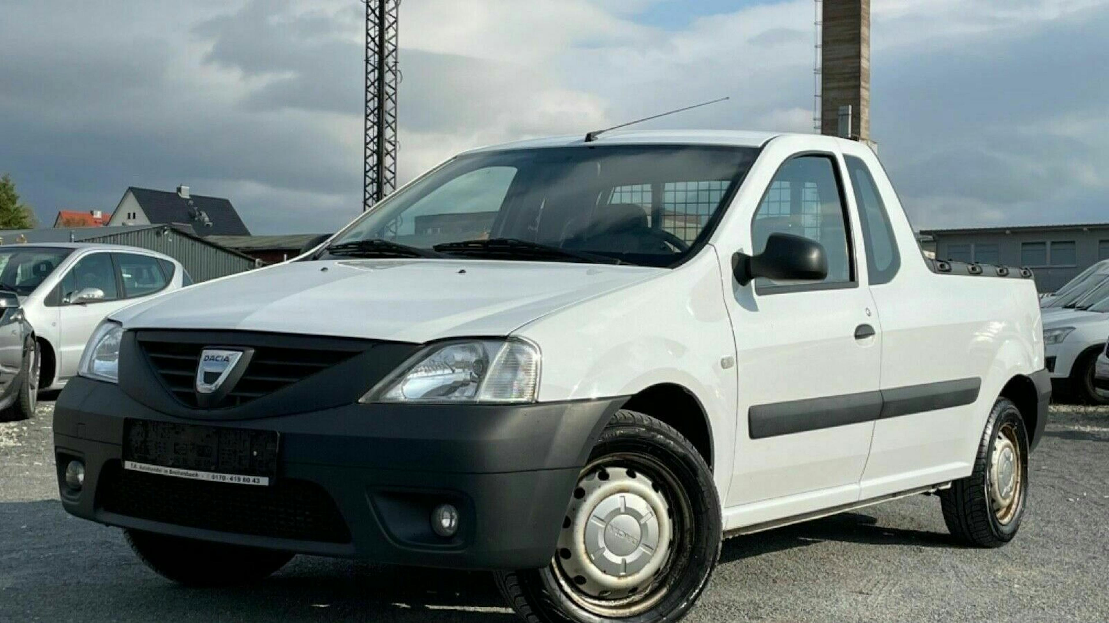 Ein weißer Dacia Logan Pick-up steht auf einem Parkplatz.