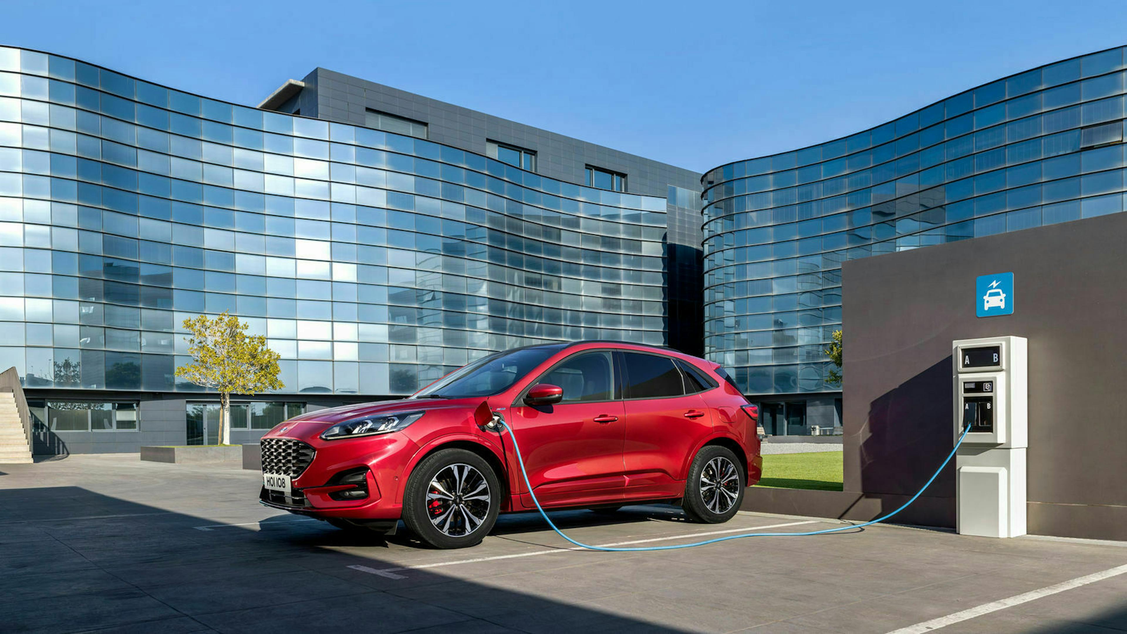 Zu sehen ist der Ford Kuga PHEV an der Ladestation