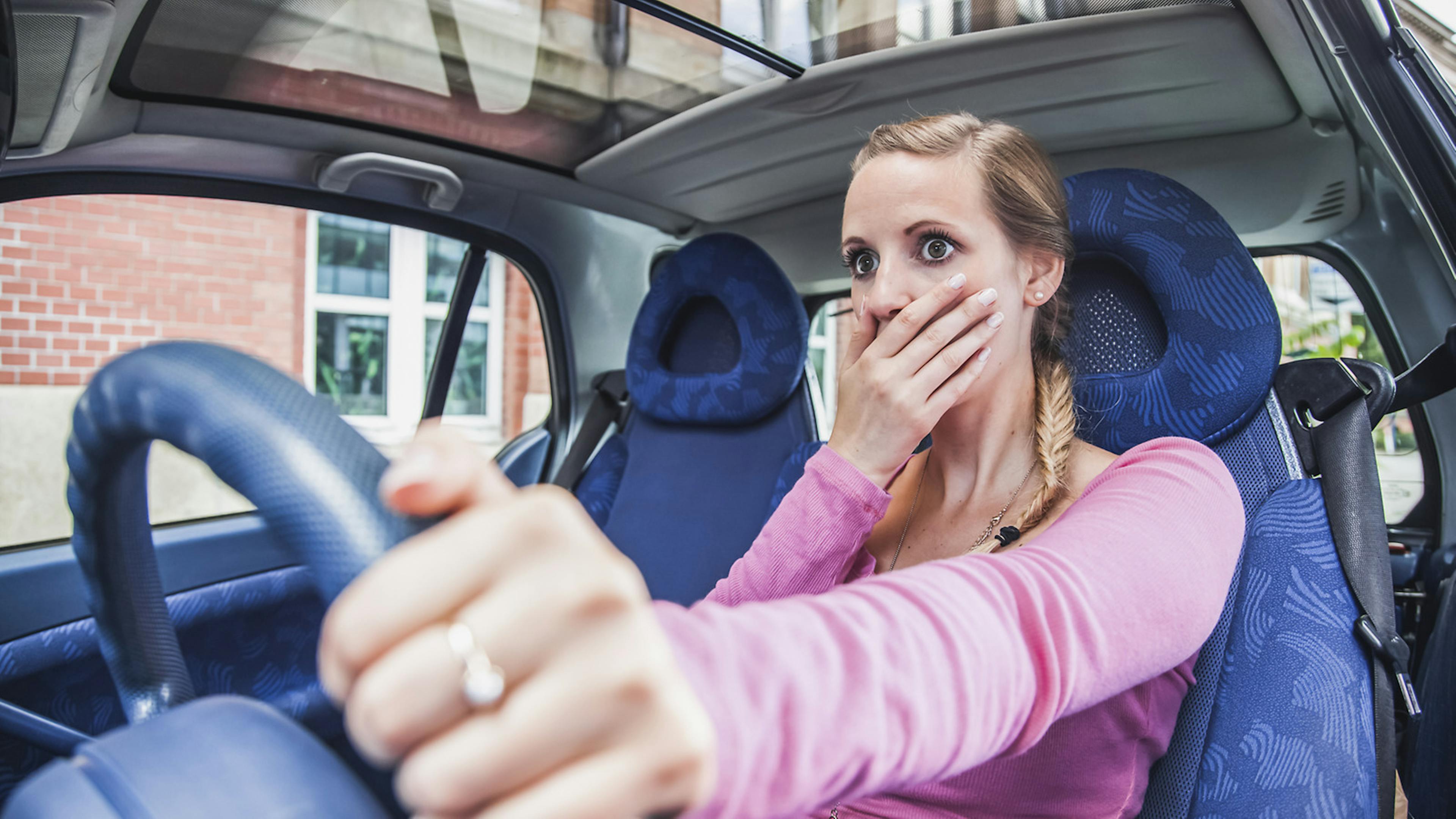 Jemand hält sich die rechte Hand vor dem Mund. Das Gesicht zeigt einen erschrockenen Ausdruck