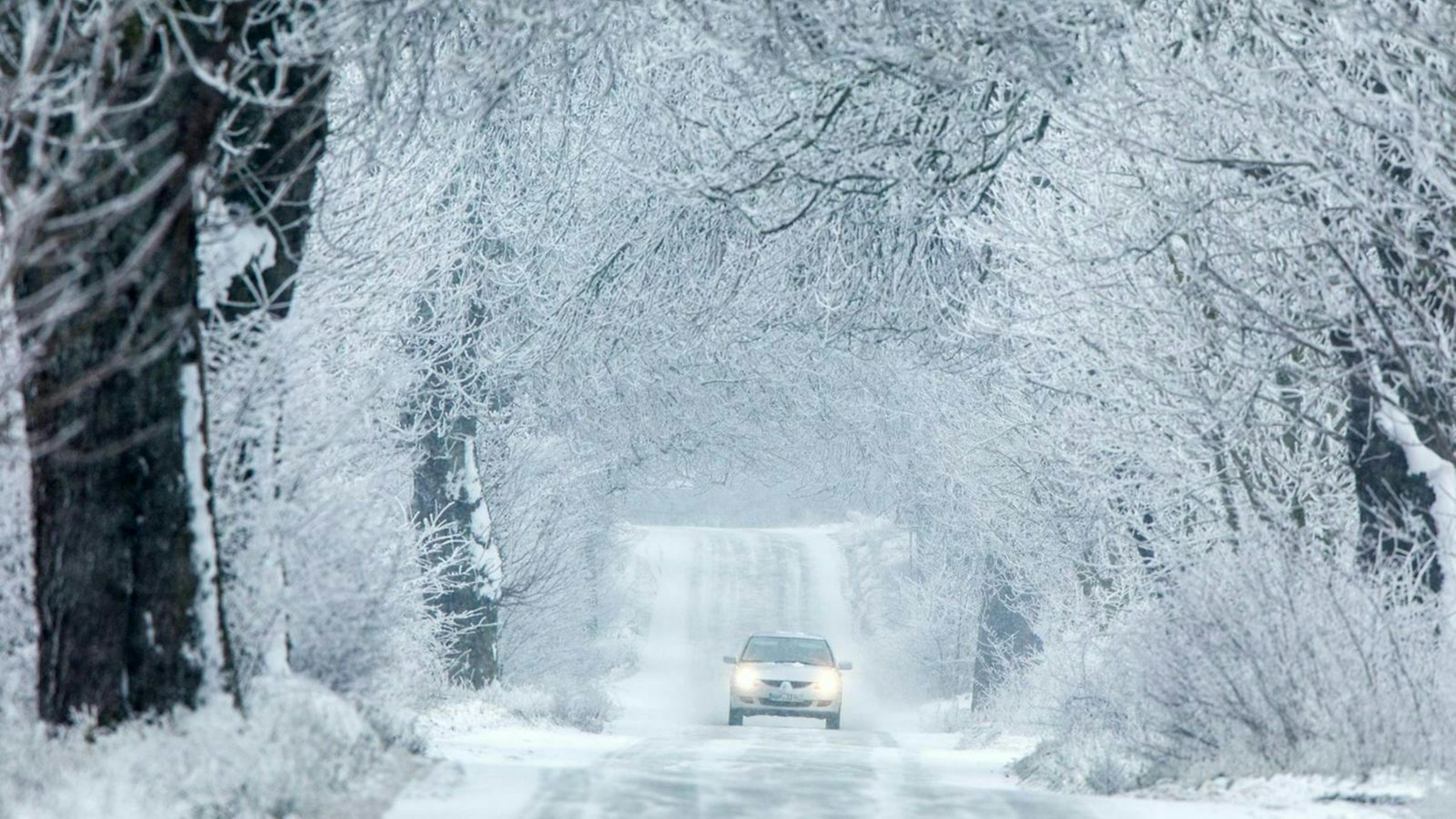 Ein Auto fährt durch eine Winterlandschaft