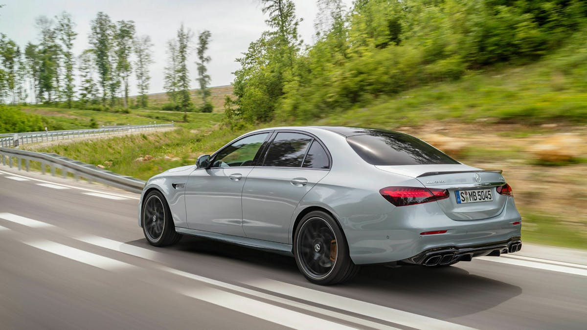 Ein silberner Mercedes E 63 S auf der Landstraße von hinten