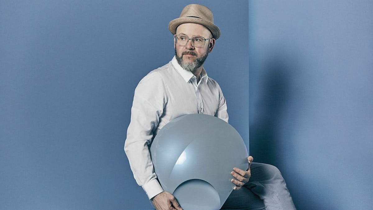 Designer Mark Gutjahr auf einem blauen Block posierend