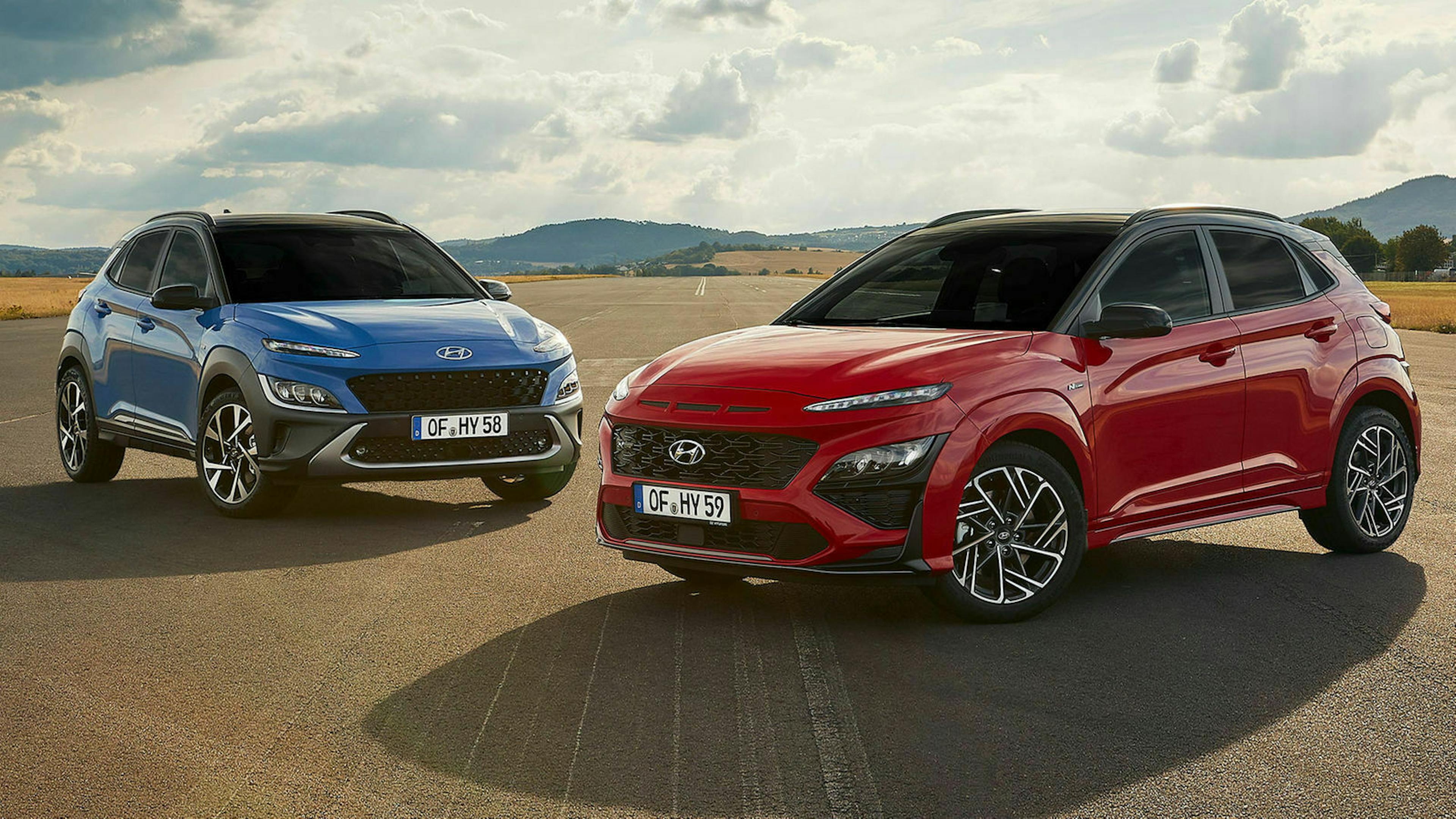 Ein roter und ein blauer Hyundai Kona N stehen auf der Rollbahn eines Flughafens