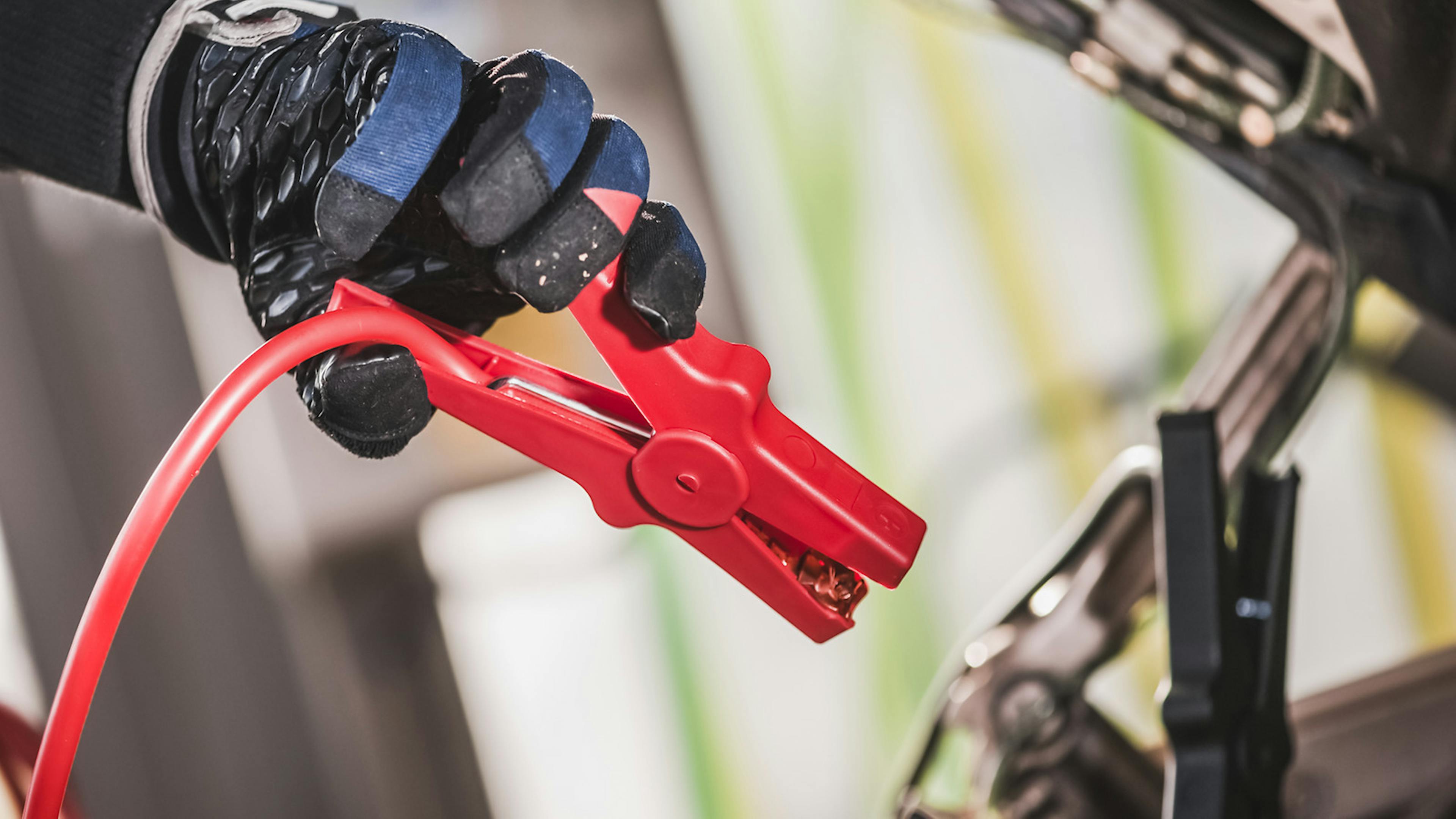 Ein Starterkabel wird an einer Autobatterie angeschlossen.