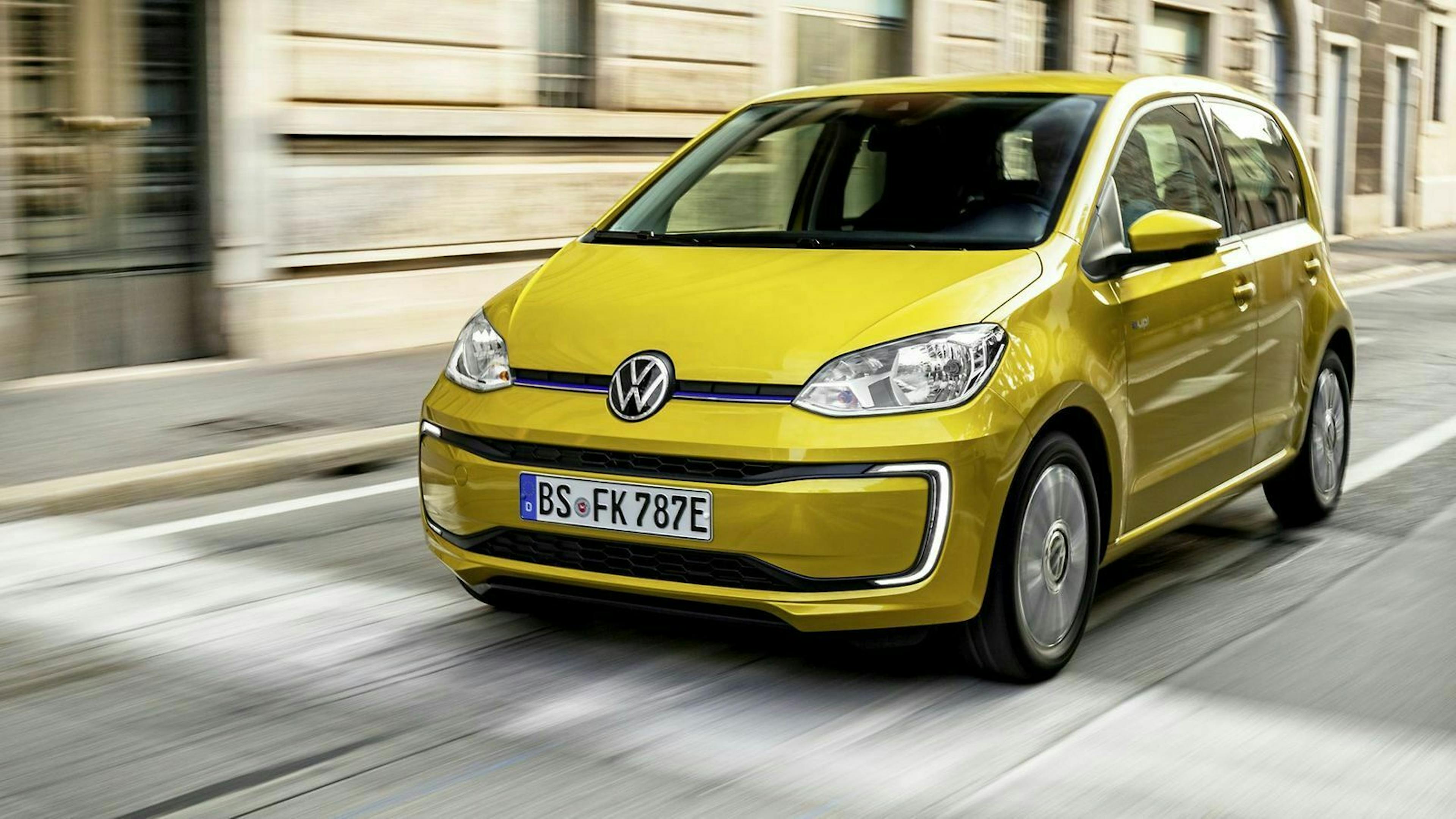 Gelber VW E-Up fahrend in der Ansicht von vorne-links