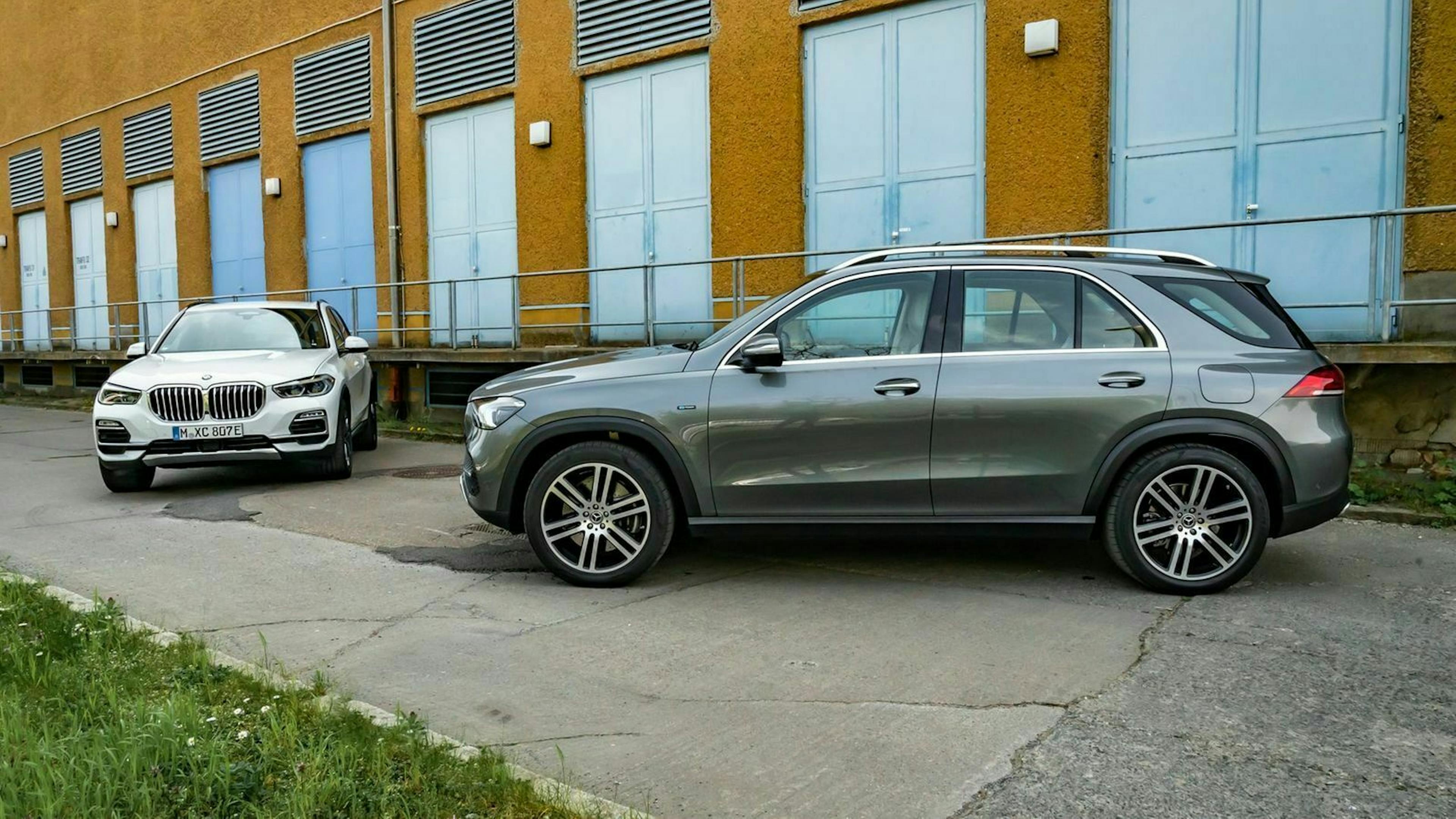 Zu sehen sind der BMW X5 (links, von vorne) und der Mercedes GLE (rechts, in seitlicher Position)