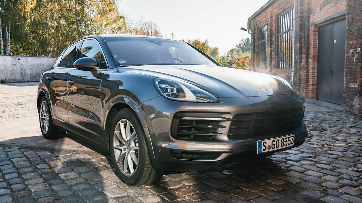 Blick auf Front des Porsche Cayenne von vorne-rechts. Sonne spiegelt sich auf der Motorhaube