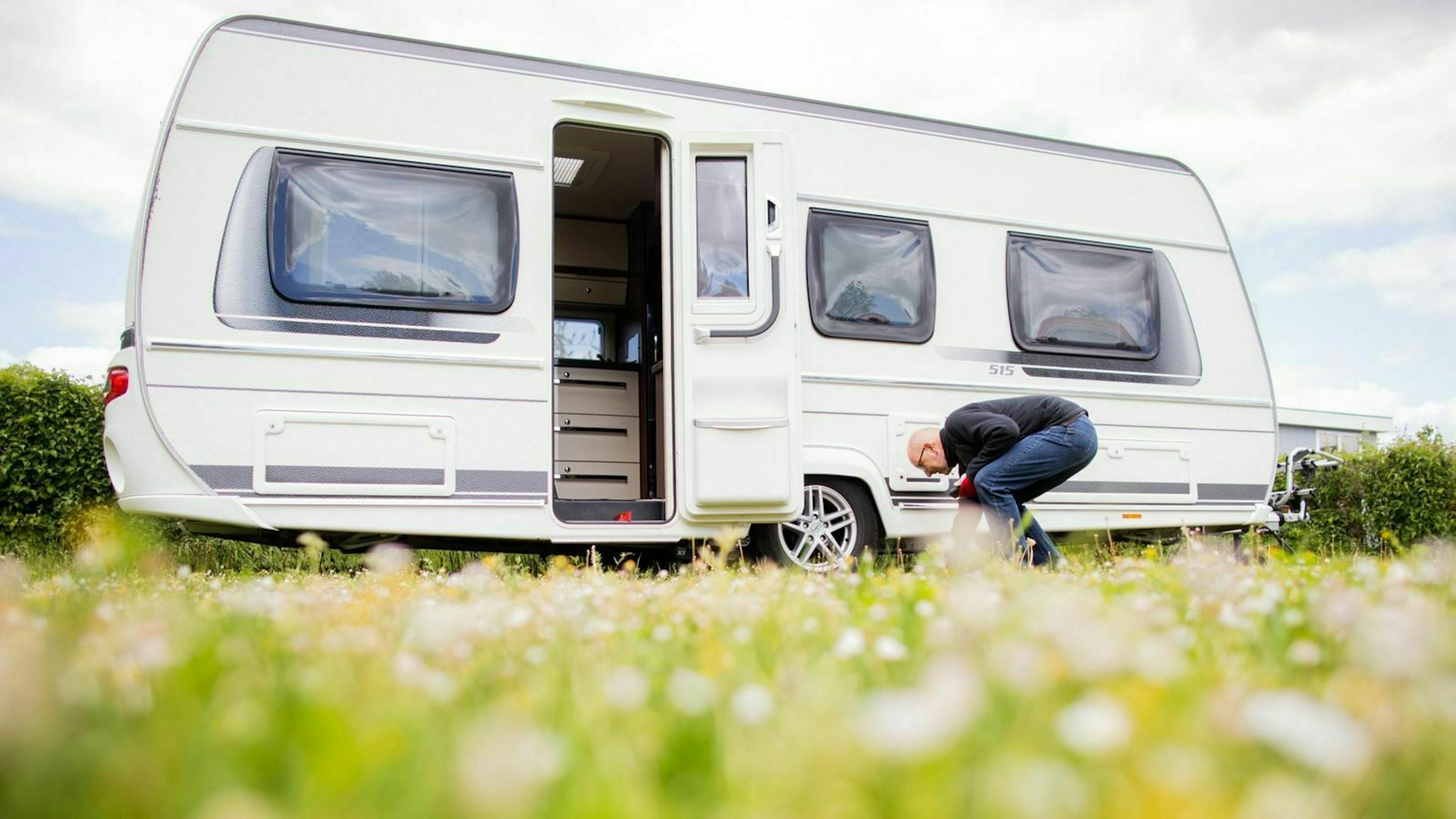 Ein Wohnwagen auf einer Wiese mit geöffneter Tür