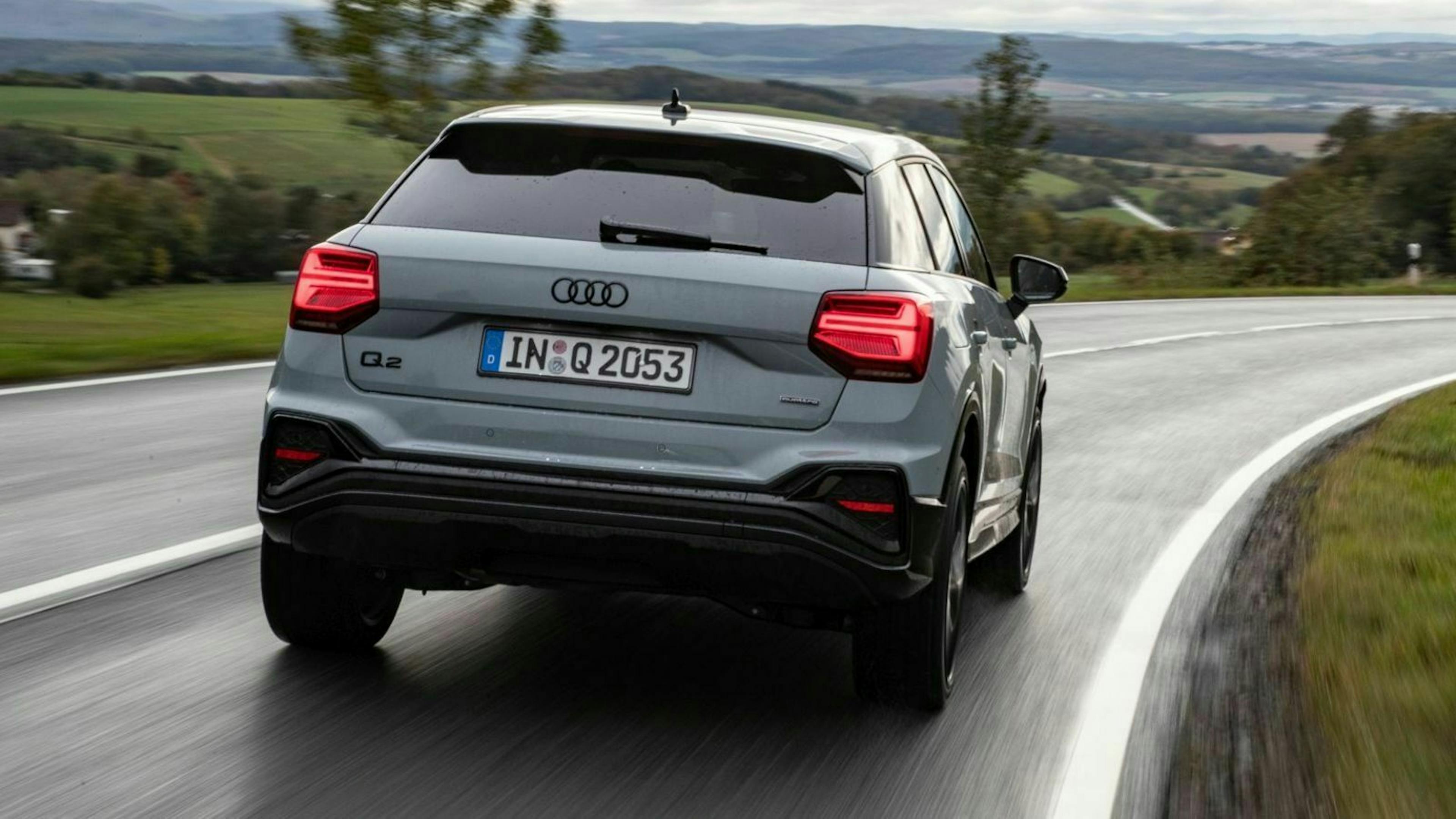 Zu sehen ist der geliftete Audi Q2 von hinten, fahrend