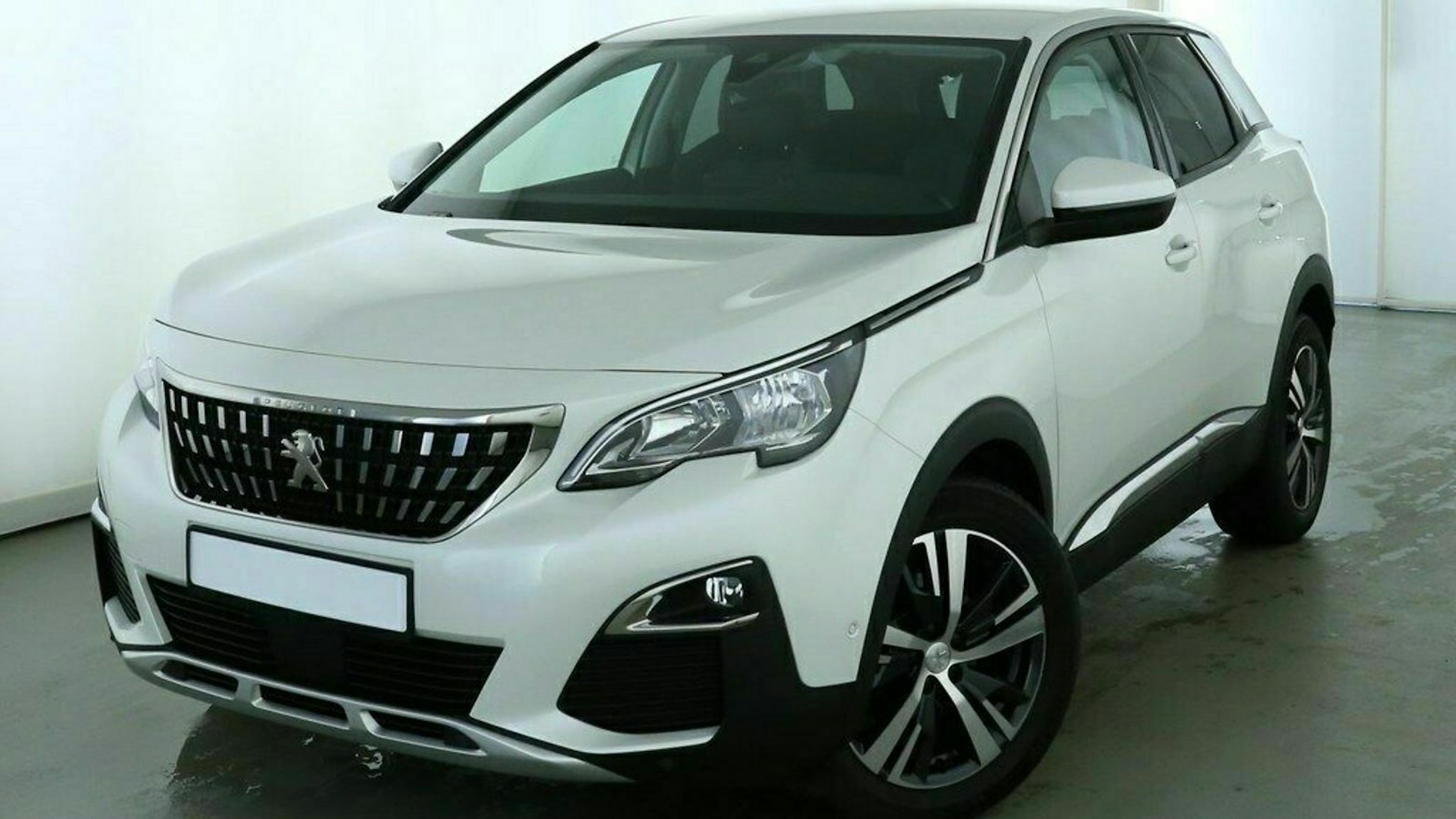 Weißer SUV mit Markenlogo auf der Motorhaube, modernes Design, ausgestellte Radläufe und sportliche Alufelgen in einer hellen Umgebung.