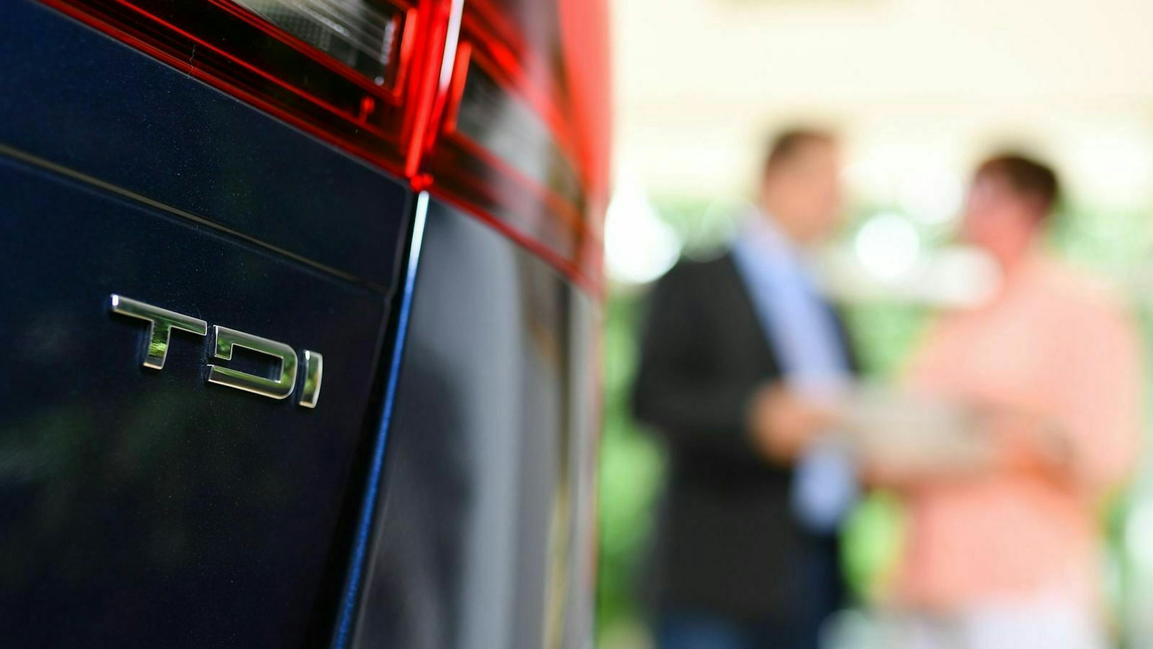 Zu sehen ist das TDI Emblem auf der Heckseite eines VW Fahrzeuges