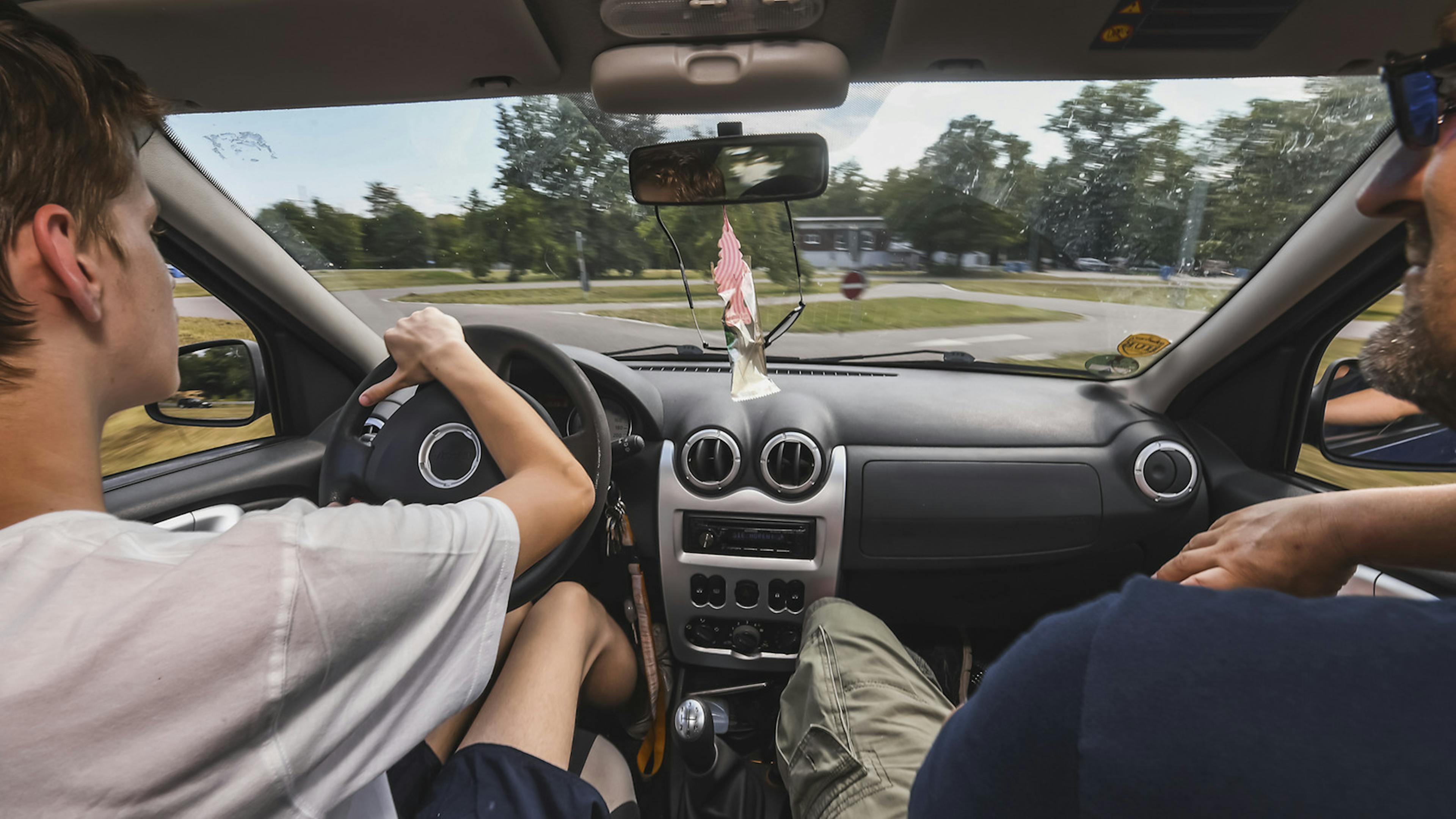 Von der Rücksitzbank aus blickt man über die Schultern von Fahrer und Beifahrer