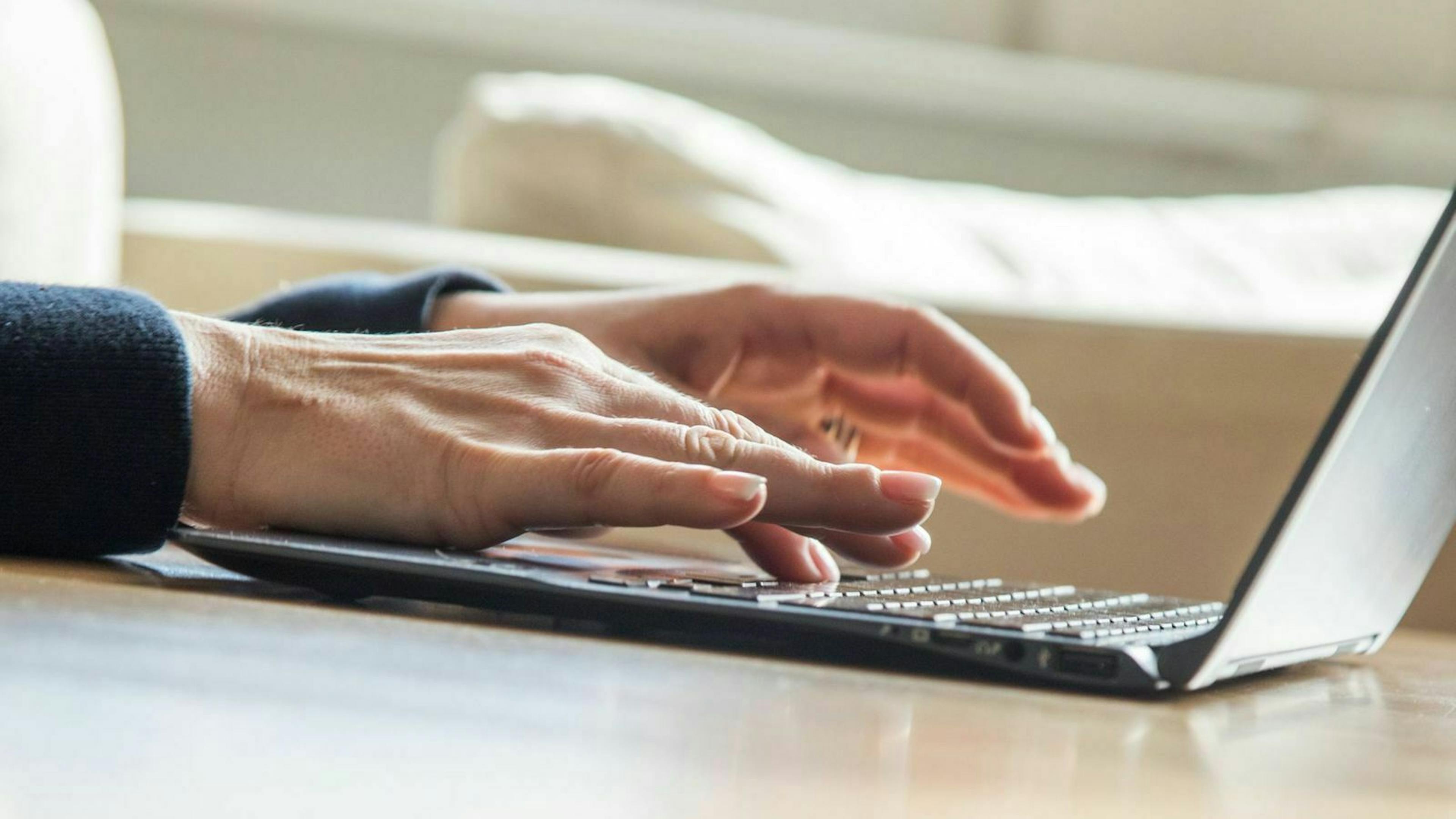 Jemand schreibt an einem Laptop