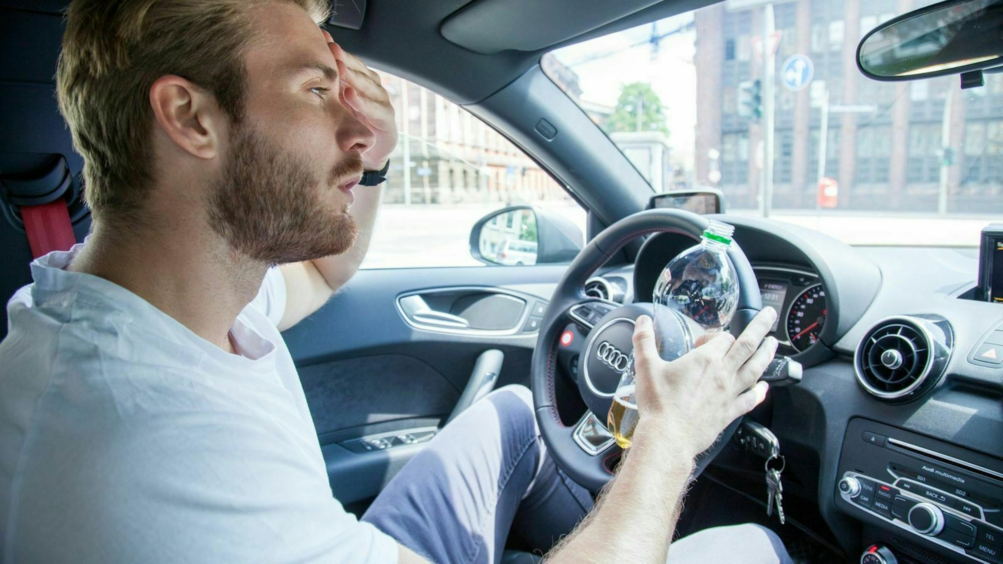 Zu sehen ist ein Mann mit einer Wasserflasche in der Hand