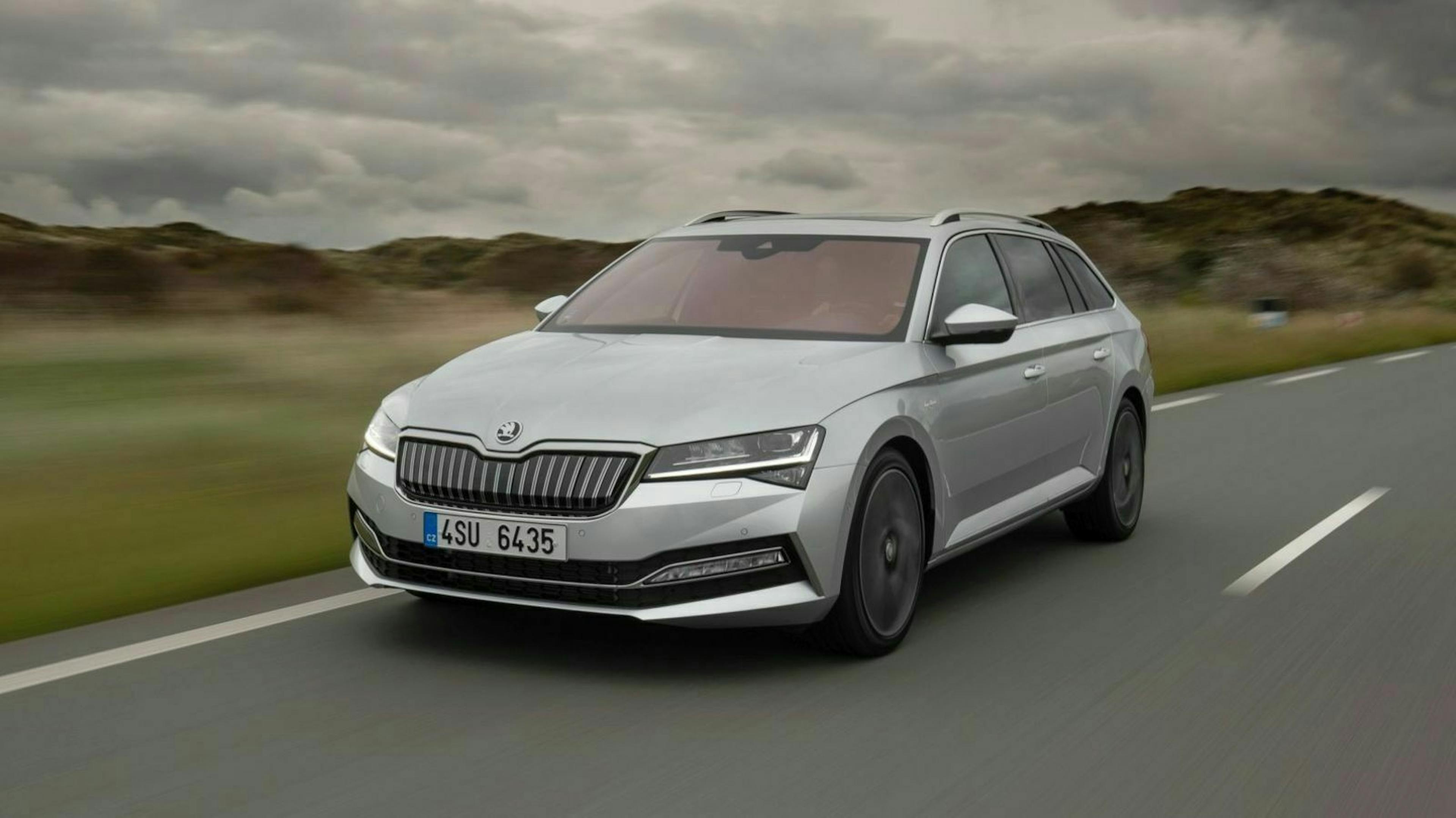 Zu sehen ist der Škoda Superb iV von vorne, fahrend