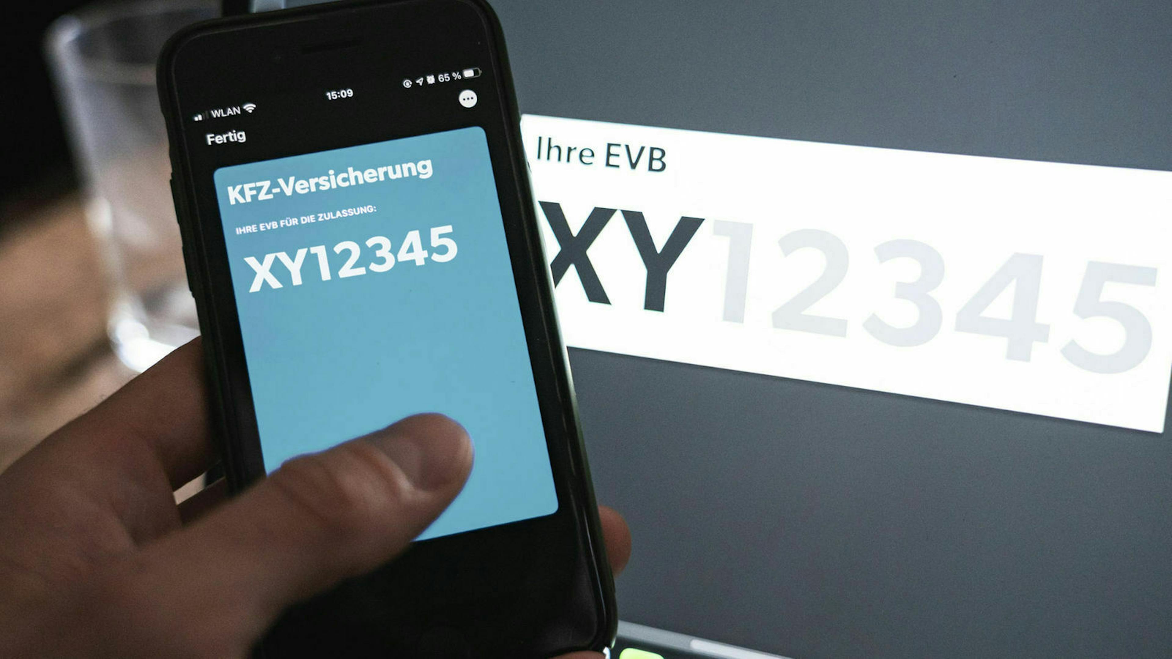 Ein Smartphone zeigt beispielhaft die eVB-Nummer eines neuen Versicherungsvertrages
