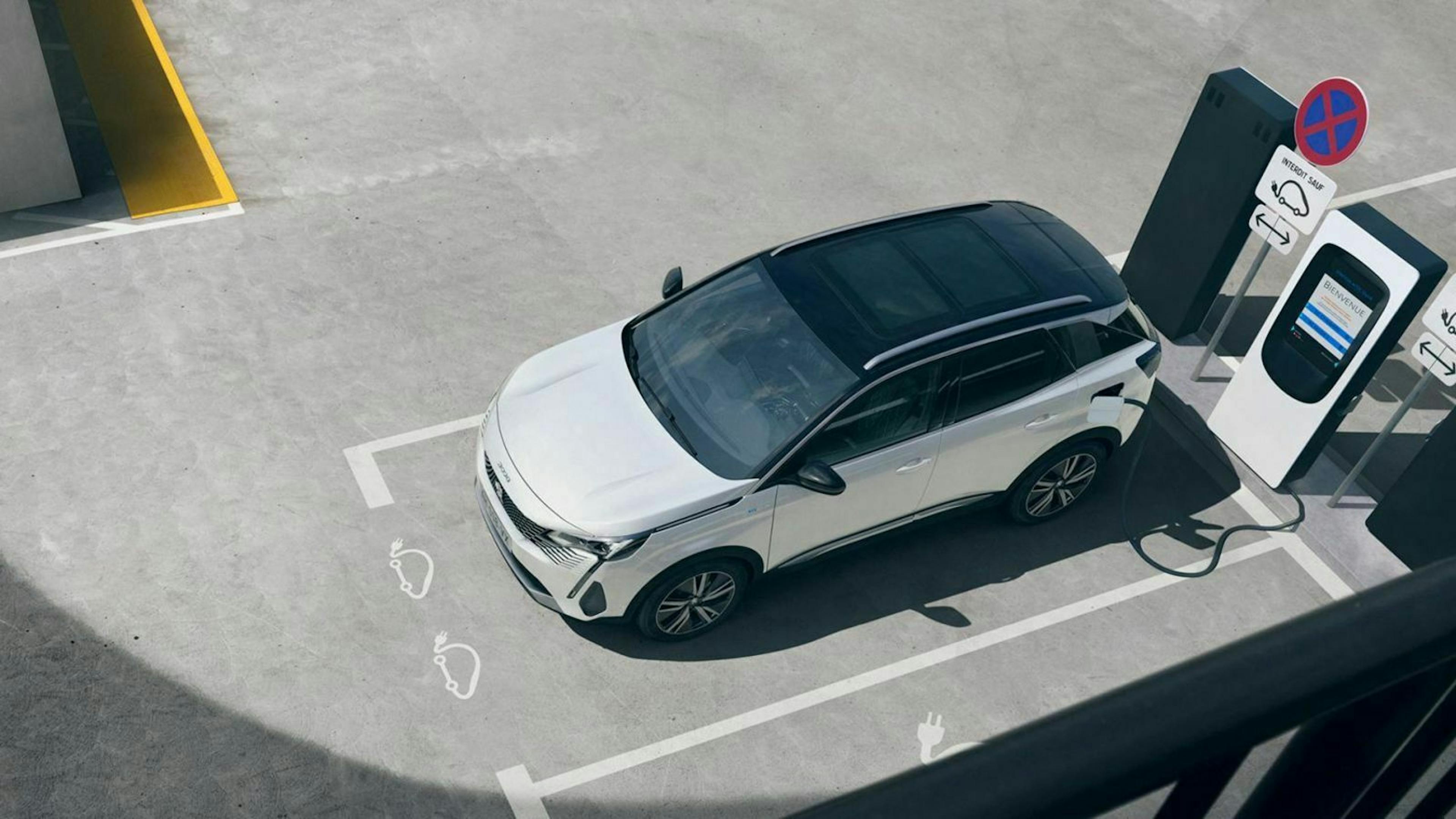 Zu sehen ist der geliftete Peugeot 3008 Hybrid an einer Ladestation