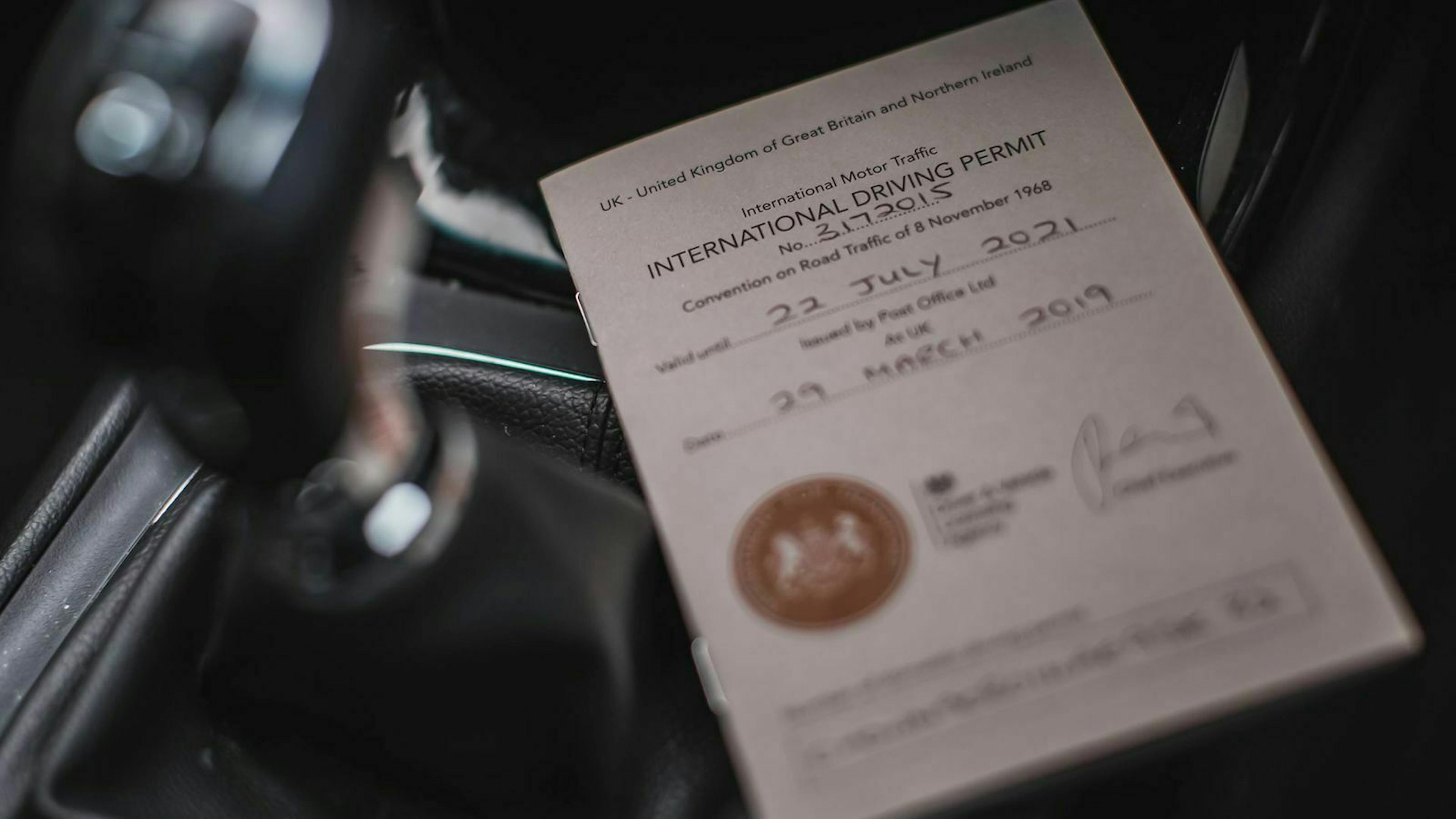 Ein internationaler Führerschein liegt auf einem Autositz.