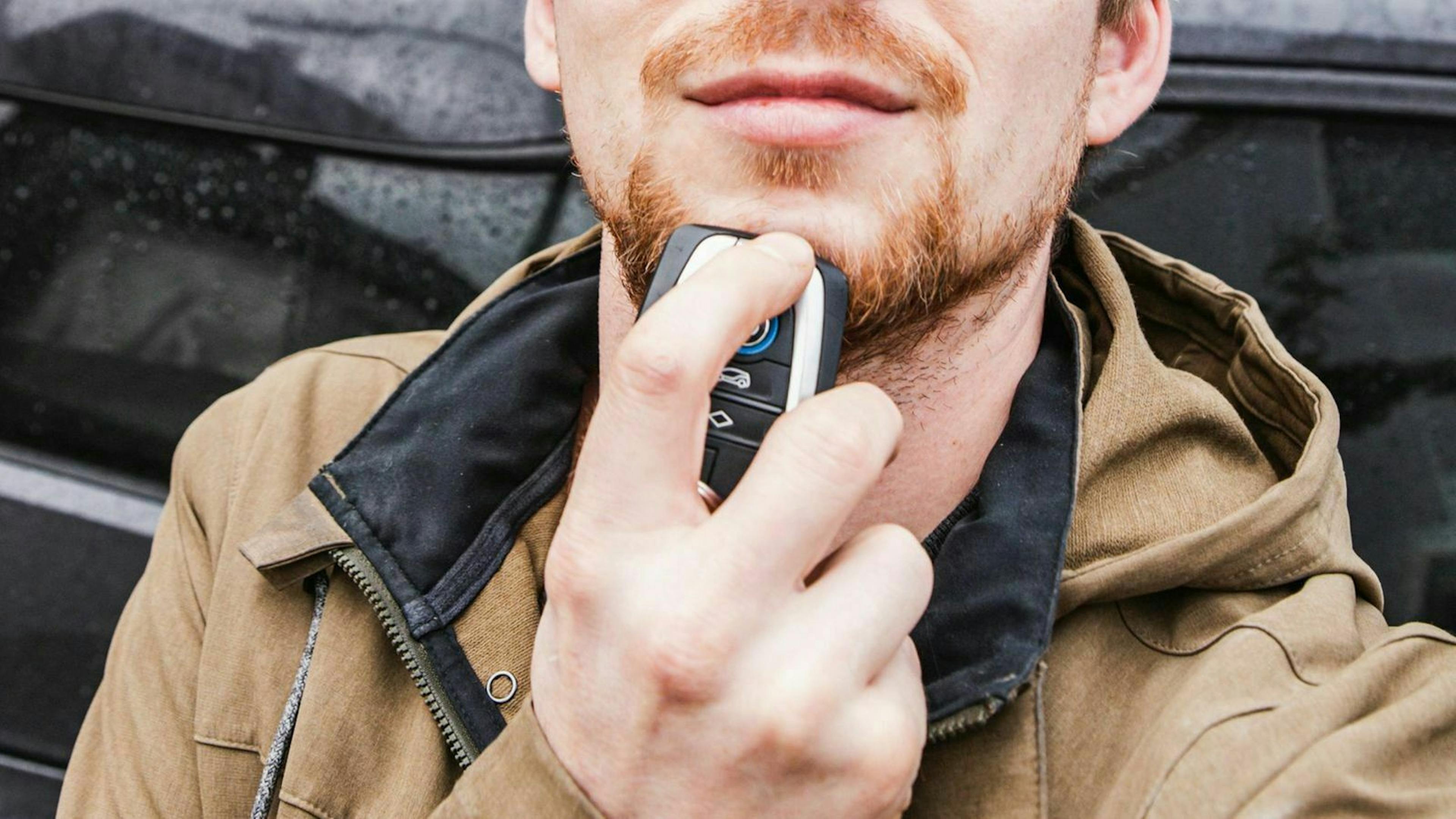 Autoschlüssel unter das Gesichr gehalten