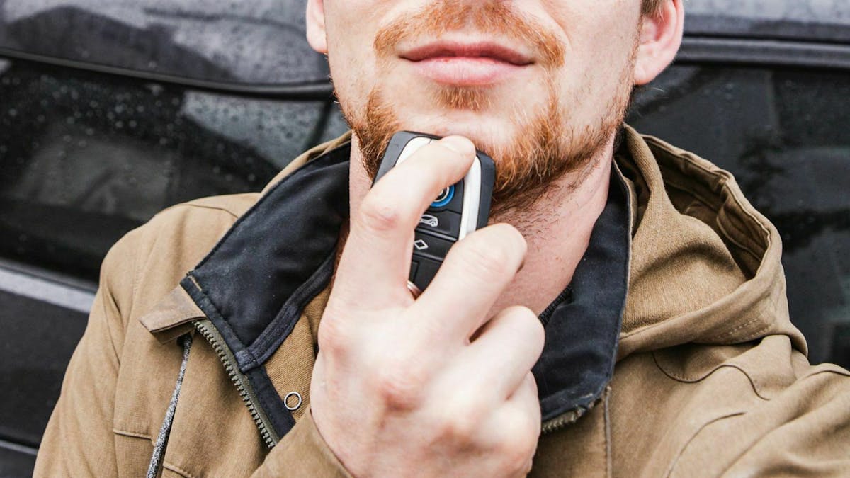 Autoschlüssel unter das Gesichr gehalten
