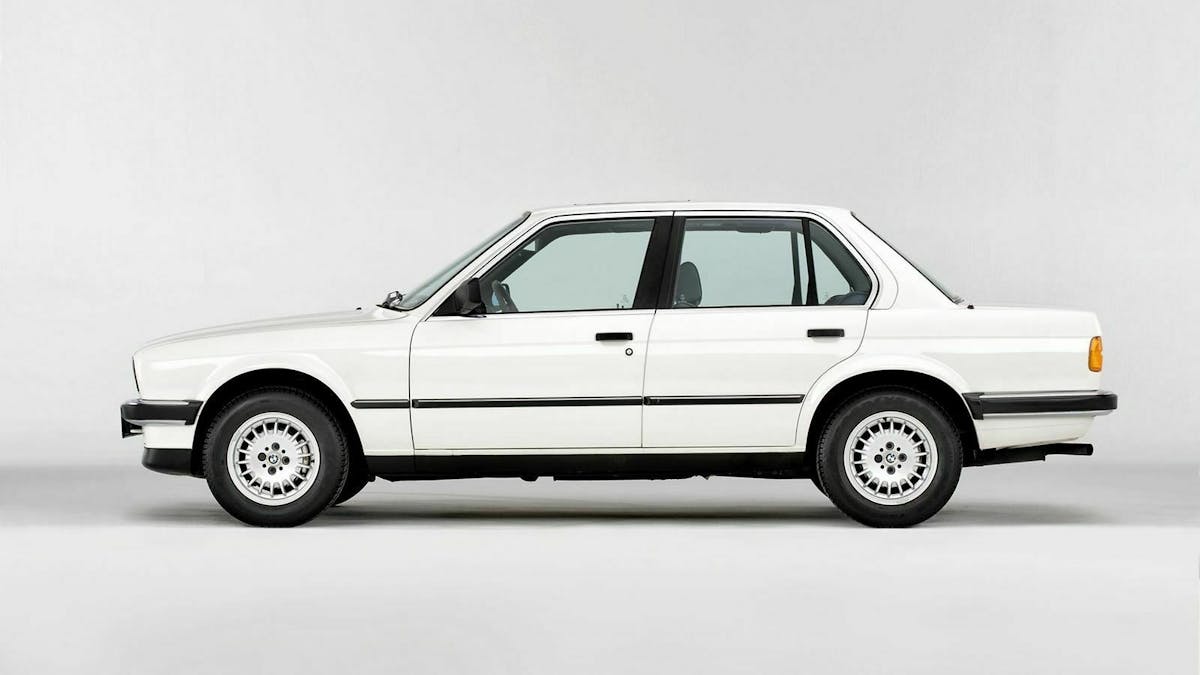 Weißer BMW 3er E30 in Seitenansicht vor weißem Hintergrund