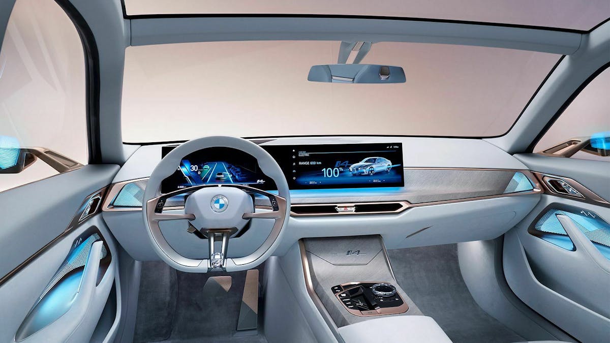 Zu sehen ist das Cockpit des BMW Concept i4 mit Ambientebeleuchtung blau